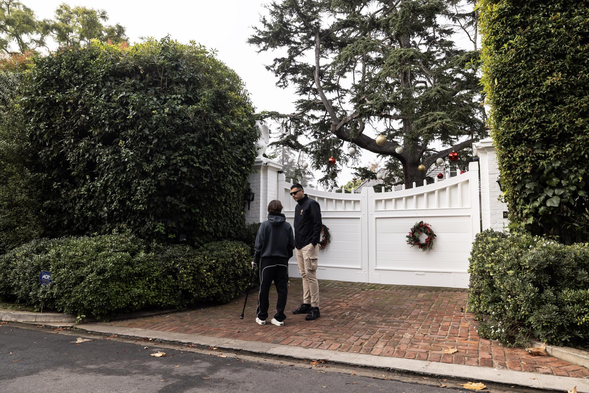 LOS ANGELES (United States), 15/12/2025.- A security person (R) stands guard in front of the Reiner residence in Brentwood, Los Angeles, California, USA, 15 December 2025. Hollywood director Rob Reiner and his wife Michele Singer Reiner were found dead in their home on 14 December, the Los Angeles Police Department said it is investigating an apparent homicide. EFE/EPA/TED SOQUI