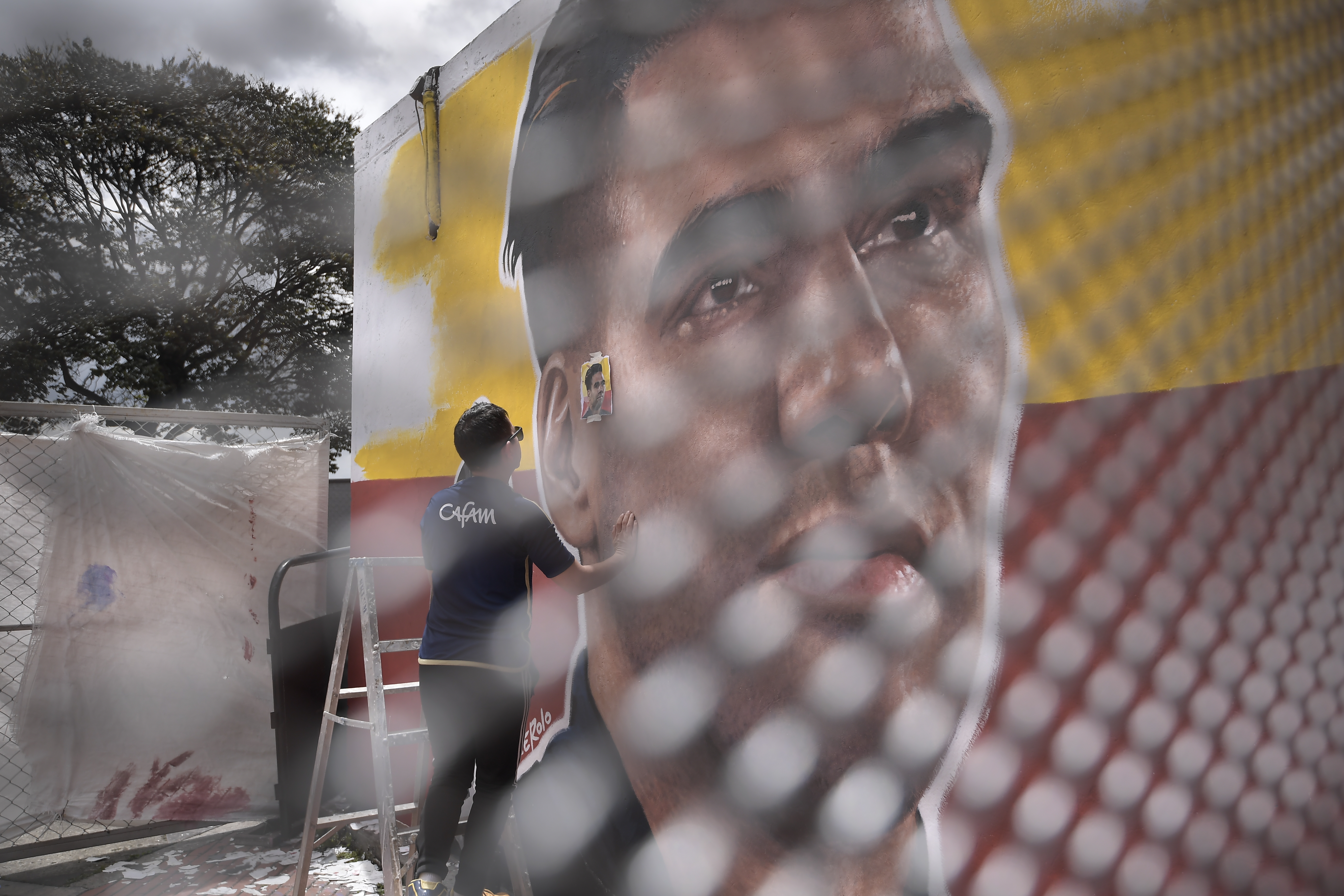Artista conocido como "Cacerolo", pinta un mural con el rostro del futbolista colombiano Radamel Falcao García, en una de las paredes del exterior del estadio Nemesio Camacho ' El Campín', este martes en Bogotá (Colombia).