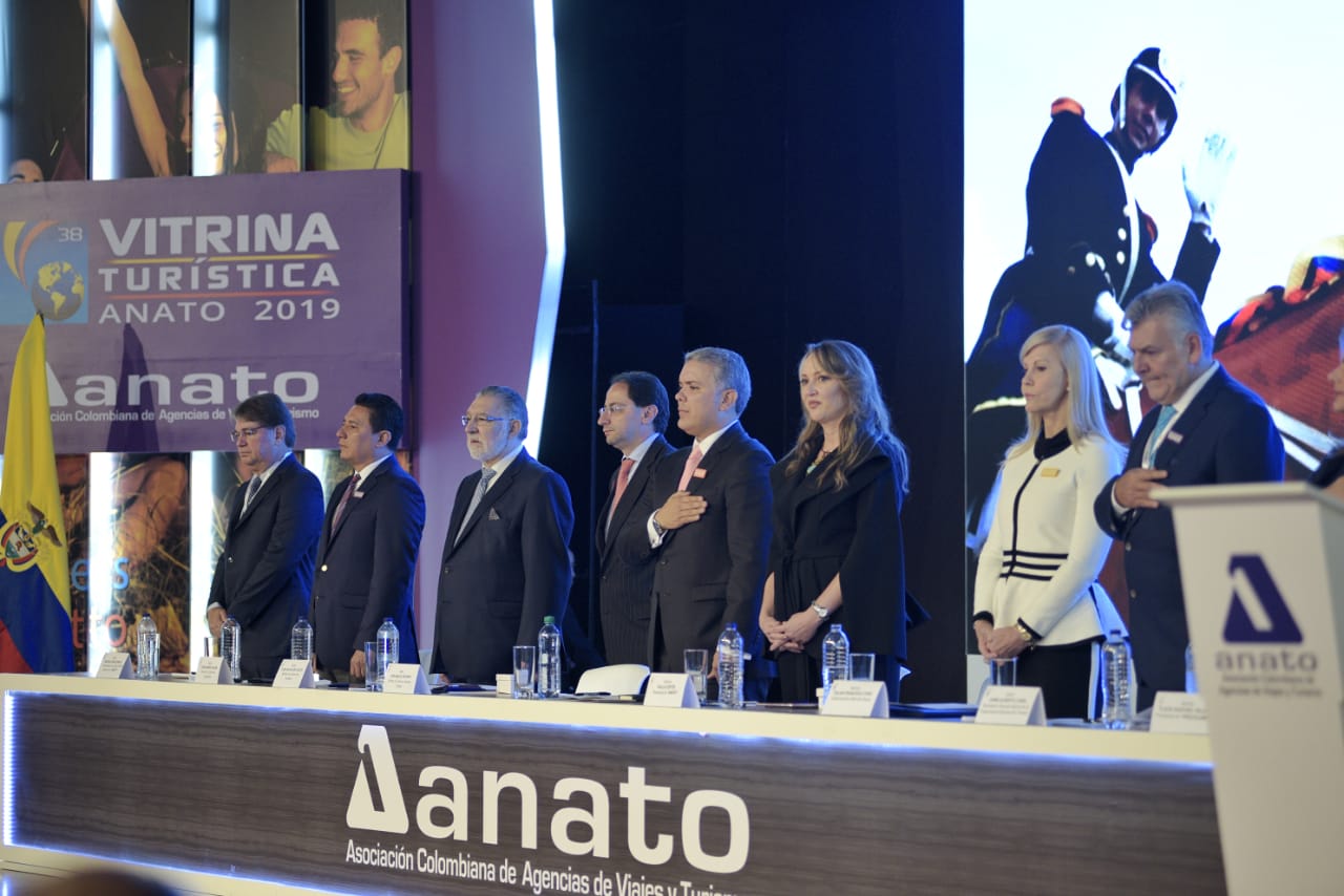 El evento de apertura contó también con la participación del cantante Gusi, imagen de la nueva campaña de promoción nacional `Yo voy´, la cual fue lanzada en el marco del evento por el primer mandatario, quien resaltó la importancia de invertir en mostrar los atractivos de Colombia para incentivar a más extranjeros a que visiten el país y a los nacionales a redescubrir su propio territorio.A través de su discurso, la dirigente gremial, distinguió a Duque como un abanderado de la industria. “Usted nos ha acompañado en los escenarios más importantes de Anato, porque venimos trabajando desde hace 70 años por el turismo colombiano y la apertura de nuevas oportunidades para el país”.Así mismo, destacó 4 aspectos imprescindibles para el buen desarrollo del turismo en el país.El primero de ellos, se relaciona con la designación de los recursos Fiscales que el Ministerio de Hacienda destina al sector, pues se han visto insuficientes para trabajar en la promoción y señalización en los destinos y sobre todo para implementar estrategias en contra de la informalidad. Igualmente, una vez más, se solicitó que los recursos del impuesto al turismo sean trasladados en su totalidad al Fontur para el desarrollo exclusivo de esta actividad en el país.La segunda, tiene que ver con que si bien, según cifras de la AeroCivil, el movimiento de pasajeros nacionales al 2018, tuvo un crecimiento del 3 %, fue uno de los más bajos durante los últimos 10 años, sumado a esto, la desaparición de rutas, concentración de mercado y menos frecuencias. Por ende, la dirigente gremial solicitó un marco regulatorio, que estimule la oferta aérea en el país, que mejore la competencia y el factor de ocupación en vuelos, incrementando la conectividad y mejorando la posibilidad de que más colombianos y extranjeros puedan acceder a todos los destinos.La tercera se relaciona con trabajar conjuntamente para erradicar la informalidad. Si bien se ha avanzado a través del grupo de protección al turista del MinCIT y la policía de turismo, a través de las brigadas de informalidad donde se revisa el cumplimiento de la norma, se necesita establecer con urgencia el endurecimiento de los requisitos del RNT y un capital mínimo financiero, en aras de proteger al consumidor y la buena imagen del sector.Por último, habló sobre la necesidad de que el Gobierno tenga mayor articulación a través del Consejo Superior de Turismo, de tal manera, que temas afines a carteras como ambiente, cultura, transporte, turismo y parques, entre otros, sean considerados de manera conjunta para generar acciones que permitan el beneficio del sector.