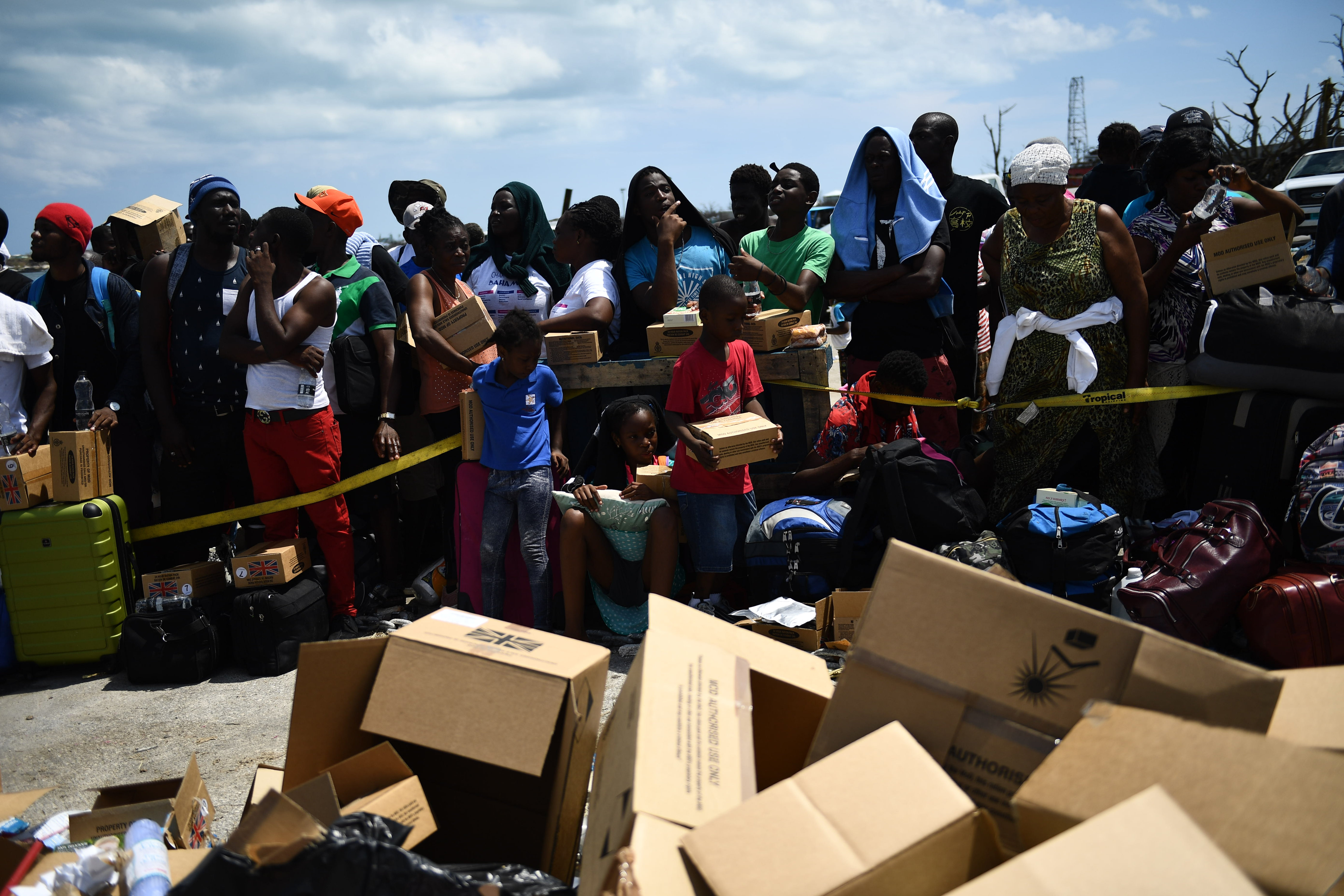 Cientos de desplazados por el huracán esperan en el puerto de las islas para ser llevados a refugios en la capital de las Bahamas, Nassau.AFPPor ahora están llegando a cuentagotas a Nassau, por aire y por mar. El ferri que trajo a los Baptiste hace dos viajes por día, trayendo entre 100 y 200 personas cada vez. En el puerto, los recibe la compañía telefónica con celulares gratuitos, porque Dorian también les quitó la forma de comunicarse con los suyos.