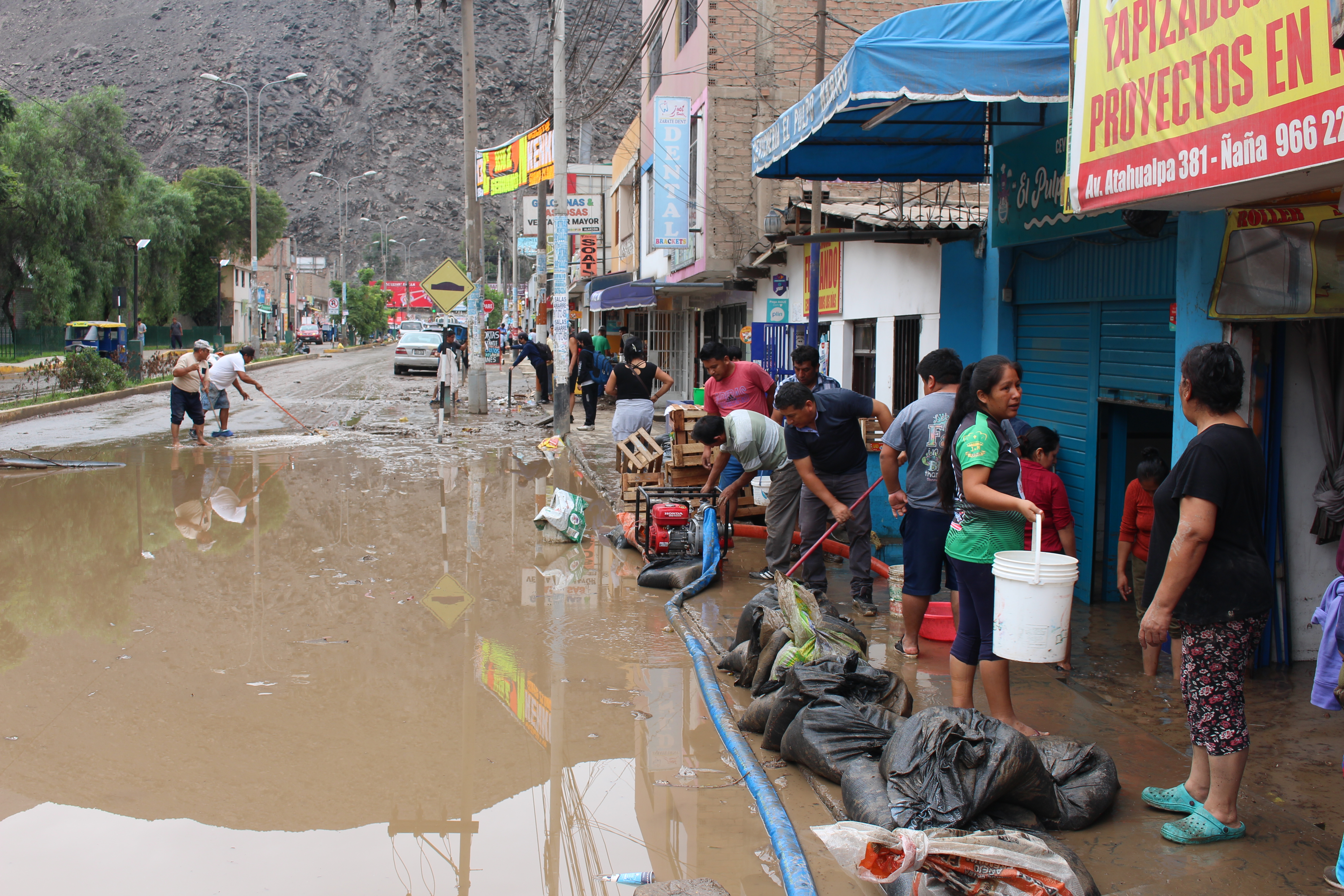 ACOMPAÑA CRÓNICA: PERÚ CICLÓN***AME2528. LIMA (PERÚ), 15/03/2023.- Residentes intentan hoy sacar el agua de sus casas y locales inundados por el ciclón Yaku, en el distrito de Chaclacayo en Lima (Perú). "Lo he perdido todo", se lamenta Fisber García, con el agua hasta las rodillas. Su tienda de confecciones, totalmente inundada desde anoche, es una de las afectadas por las lluvias provocadas por el ciclón Yaku en Lima, que ha mostrado una vez más la poca prevención de las autoridades ante este tipo de fenómenos, escasos pero advertidos en la desértica capital de Perú. El distrito limeño de Chaclacayo, a las afueras de la capital y rodeado de cerros, está regado por enormes charcos como una especie de pista. EFE/ Paula Bayarte