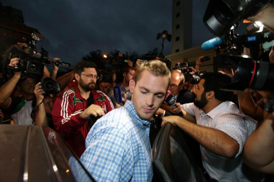 Los nadadores olímpicos estadounidenses Jack Conger y Gunnar Bentz (c), tras su declaración a las autoridades brasileras. / EFE