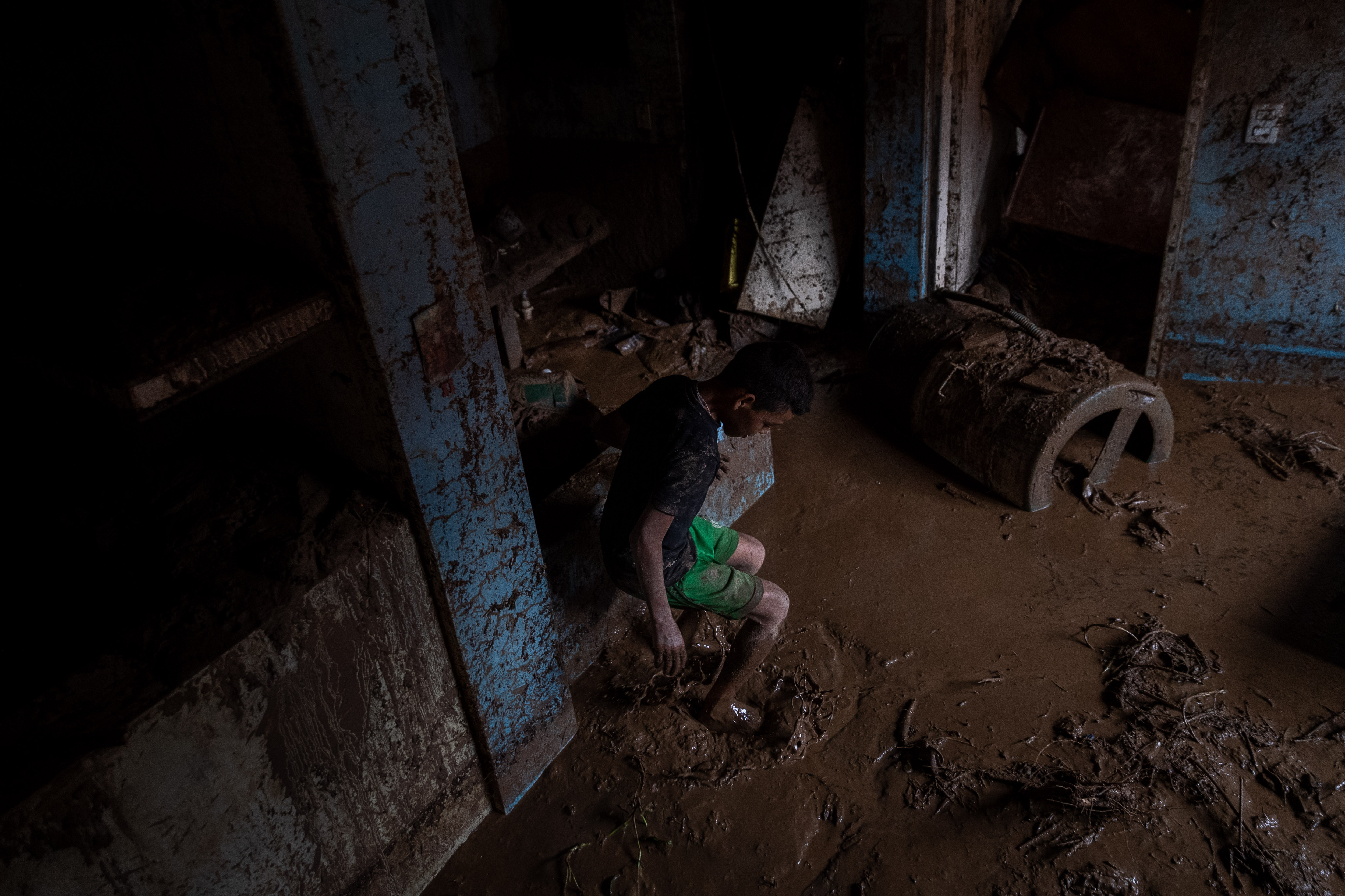 AME3286. TEJERIAS (VENEZUELA), 09/10/2022.- Un niño camina entre el lodo que quedó en su vivienda tras las lluvias y el desbordamiento de la quebrada (rio) Los Patos en Las Tejerias, estado Aragua (Venezuela). La crecida de una quebrada este sábado arrastró viviendas, mobiliario urbano, e inundó las calles de la localidad, arrasando con todo lo que el agua encontró a su paso. El Gobierno desplegó hoy organismos de salvamento, seguridad ciudadana, así como cuadrillas de mantenimiento y limpieza, y personal de diversas instituciones para "la atención integral del pueblo", dijo el presidente Nicolás Maduro a través de su cuenta de Twitter.EFE/ Rayner Peña R.