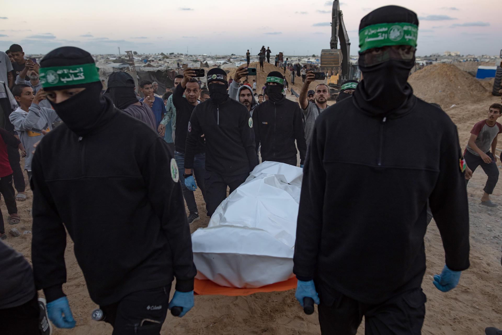 Khan Yunis (-), 28/10/2025.- Hamas militants carry a white bag containing a body after retrieving it from a tunnel in Khan Yunis, southern Gaza, 28 October 2025. The retrieval is part of an ongoing operation to find Israeli hostage bodies under a ceasefire agreement between Israel and Hamas. EFE/EPA/HAITHAM IMAD