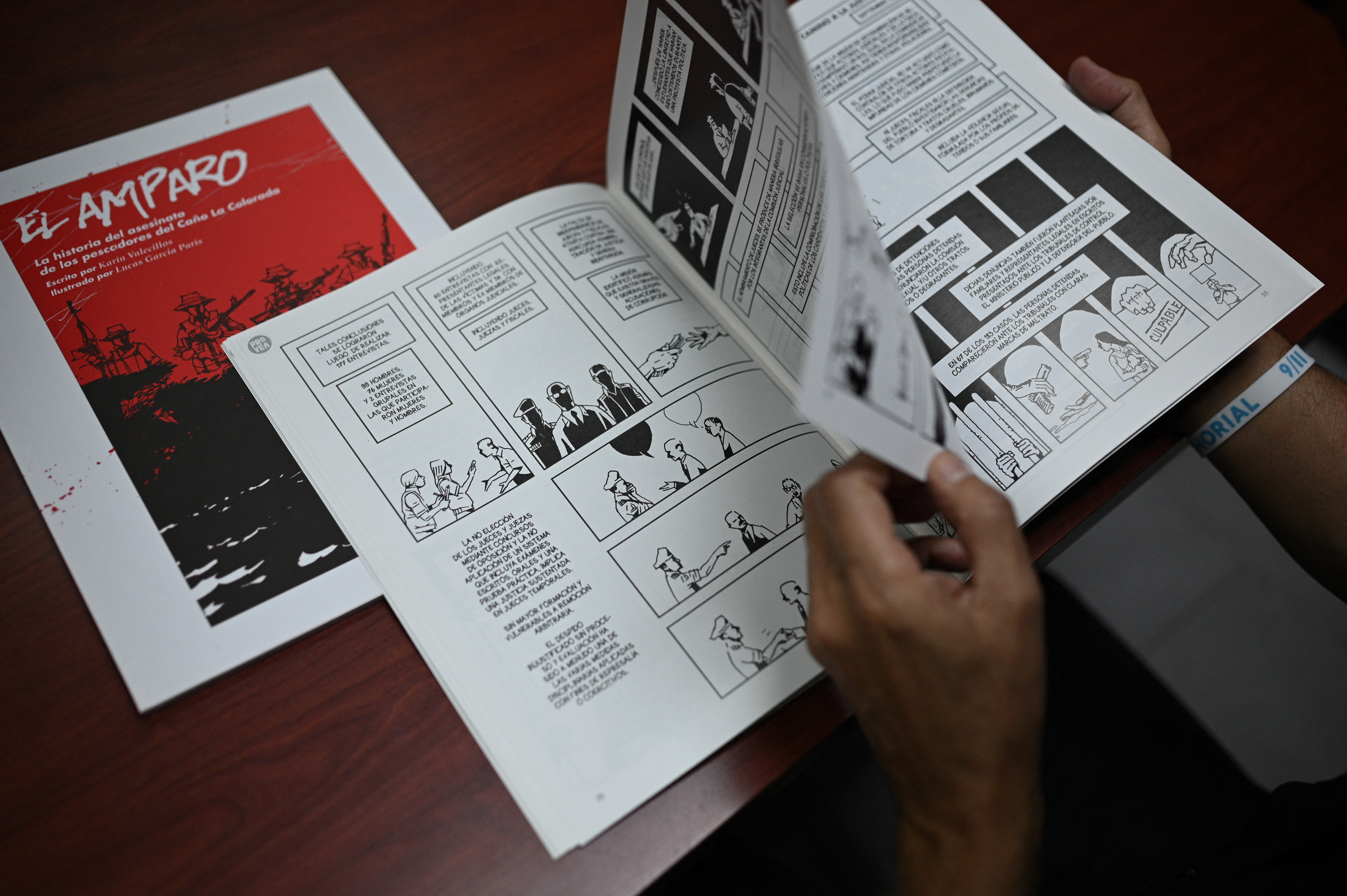 Marino Alvarado, coordinador de la ONG de derechos humanos PROVEA, lee el cómic "El Amparo" en su oficina de Caracas el 19 de diciembre de 2023.