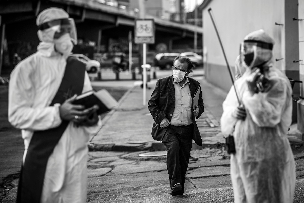 Parte del trabajo del sacerdote y la violinista es levantar los ánimos con una palabra de esperanza, pues con 2.910 casos de fallecidos por COVID-19 en Bogotá, la fe de muchos empieza a tambalear. / Mauricio Alvarado