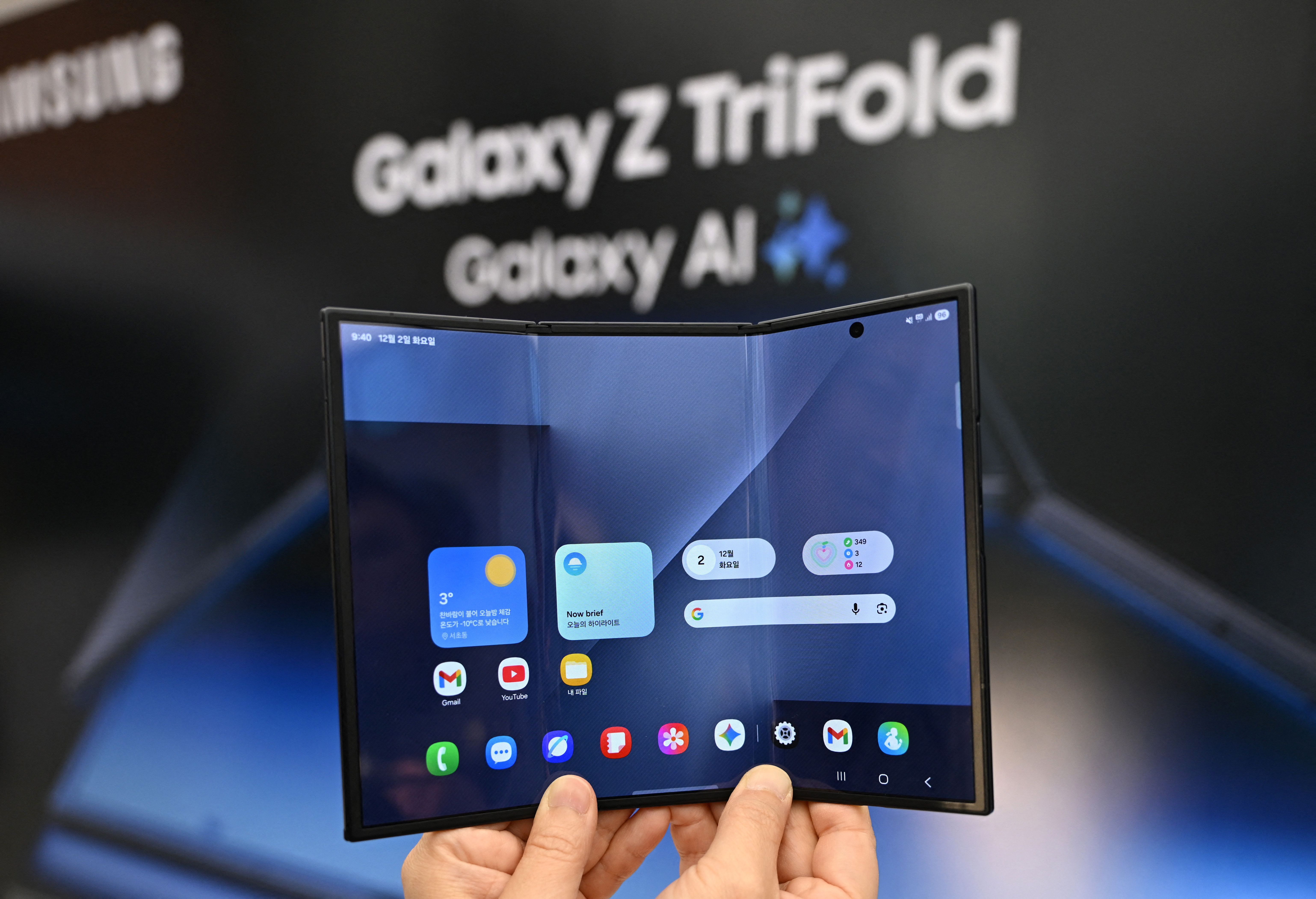 Un visitante sostiene un smartphone Samsung Galaxy Z TriFold durante un evento de lanzamiento en una tienda Samsung en Seúl el 2 de diciembre de 2025. Samsung Electronics presentó su primer teléfono plegable el 2 de diciembre, mientras el conglomerado se apresura a demostrar que puede seguir el ritmo de sus rivales en IA generativa.