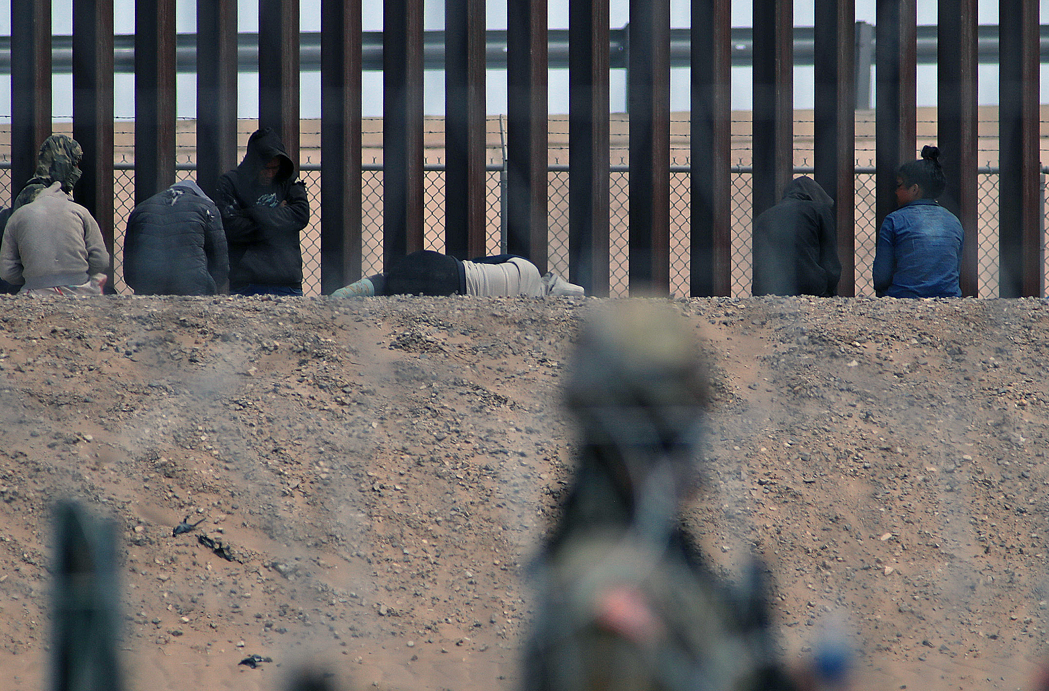MEX6109. CIUDAD JUÁREZ (MÉXICO), 28/04/2024.- Migrantes permanecen entre la frontera con Estados Unidos, el 27 de abril de 2024, en Ciudad Juárez, estado de Chihuahua (México). Migrantes que han logrado llegar al río Bravo, la frontera entre la mexicana Ciudad Juárez y El Paso, Texas, aseguran temer al crimen organizado luego de la masacre de 9 personas esta semana y que, según las autoridades, podría haber sido perpetrada por traficantes de personas. EFE/Luis Torres