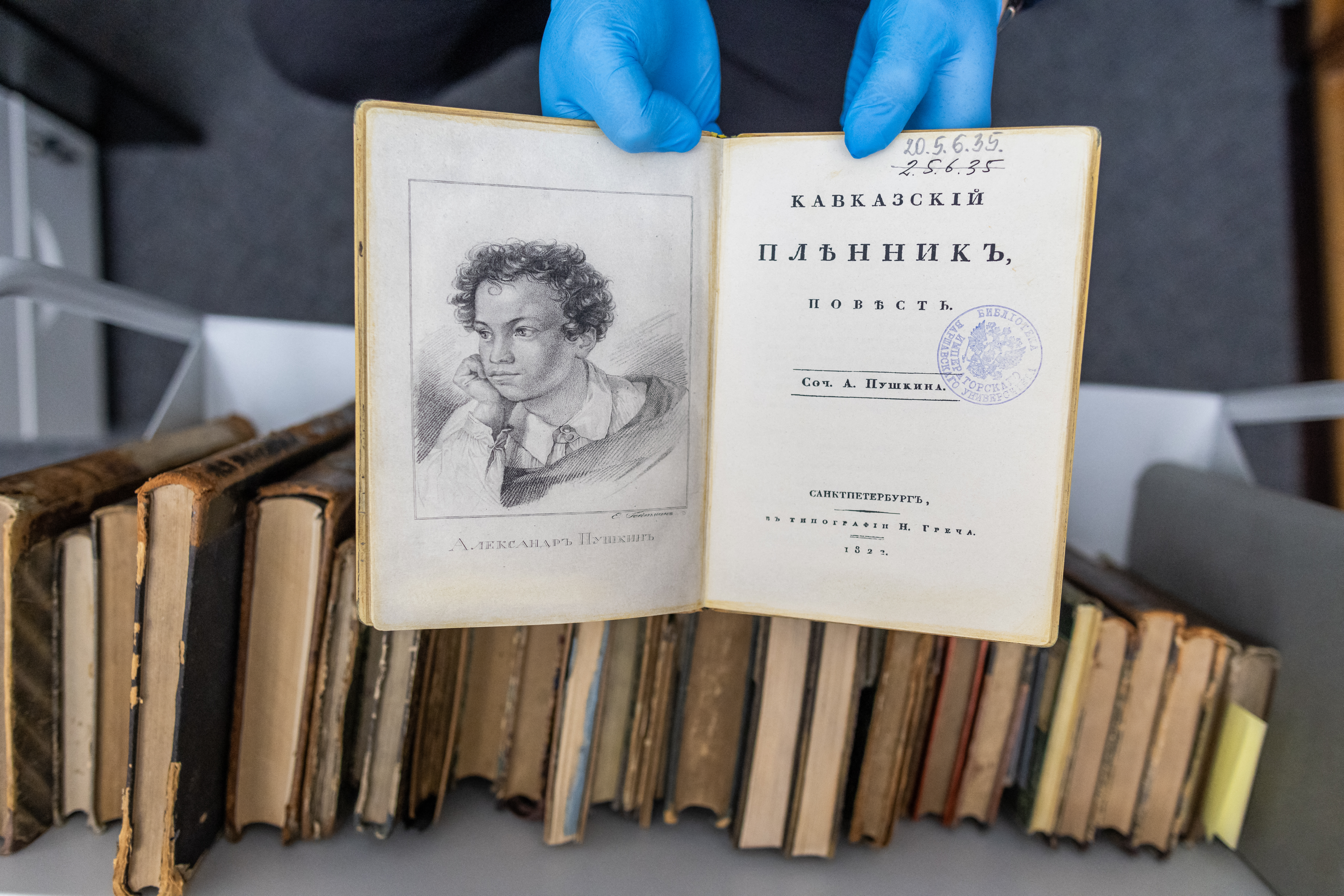 Un empleado de la universidad presenta una copia falsa de una primera edición del libro de 1822 'Kavkazskiy plennik: povest' de Alexander Pushkin en la biblioteca de la Universidad de Varsovia en Varsovia, Polonia, el 14 de noviembre de 2023. Una serie de robos de clásicos rusos raros por valor de millones de euros de bibliotecas de toda Europa del Este ha dejado un rastro que apunta hasta Moscú.