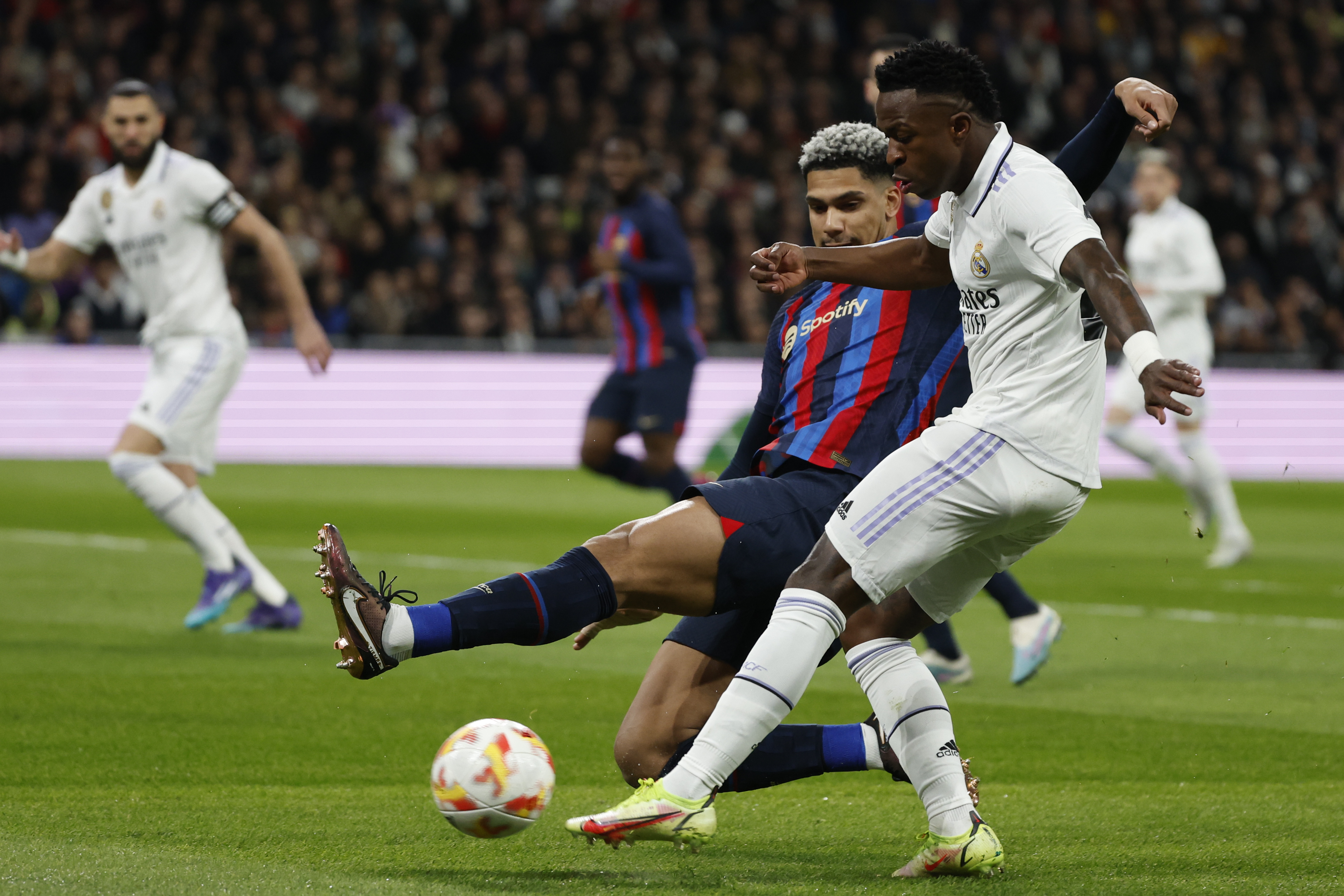 MADRID, 02/03/2023.- El delantero del Real Madrid Vinicius Junior trata de superar a Ronald Araújo (i), del Barcelona, durante el partido de ida de las semifinales de la Copa del Rey que Real Madrid y FC Barcelona disputan este jueves en el estadio Santiago Bernabéu. EFE/Juanjo Martín