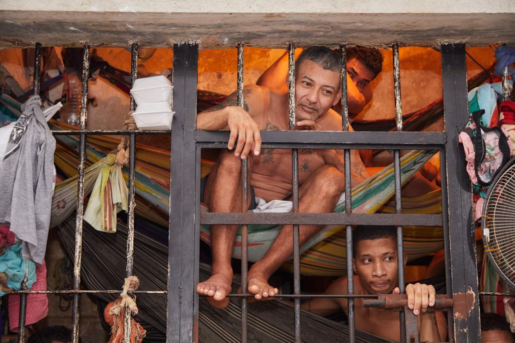 Varios hombres tres una reja en una estación de Policía de Riohacha, La Guajira.