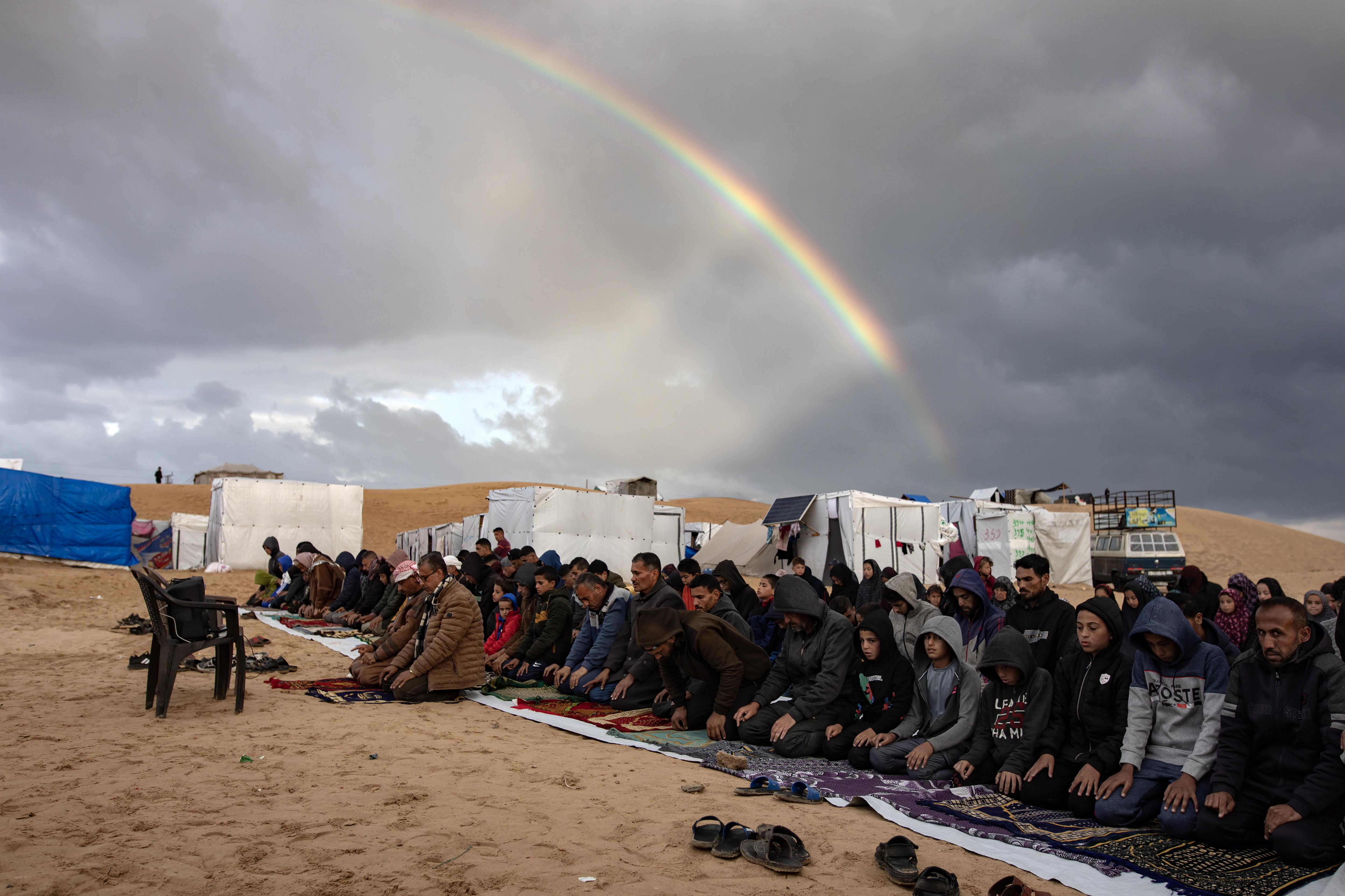 Rafah (-), 10/04/2024.- A rainbow appears as displaced Palestinians, who escaped the ongoing conflict between Israel and Hamas, perform Eid al-Fitr prayers next to their tents set up near the Egyptian border, at the Rafah camp in the southern Gaza Strip, 10 April 2024. Muslims worldwide celebrate Eid al-Fitr, a two or three-day festival at the end of the Muslim holy fasting month of Ramadan.It is one of the two major holidays in Islam. During Eid al-Fitr, Most People travel to visit each other in town or outside of it and children receive new clothes and money to spend for the occasion.More than 33,100 Palestinians and over 1,450 Israelis have been killed, according to the Palestinian Health Ministry and the Israel Defense Forces (IDF), since Hamas militants launched an attack against Israel from the Gaza Strip on 07 October 2023, and the Israeli operations in Gaza and the West Bank which followed it. (Egipto) EFE/EPA/HAITHAM IMAD