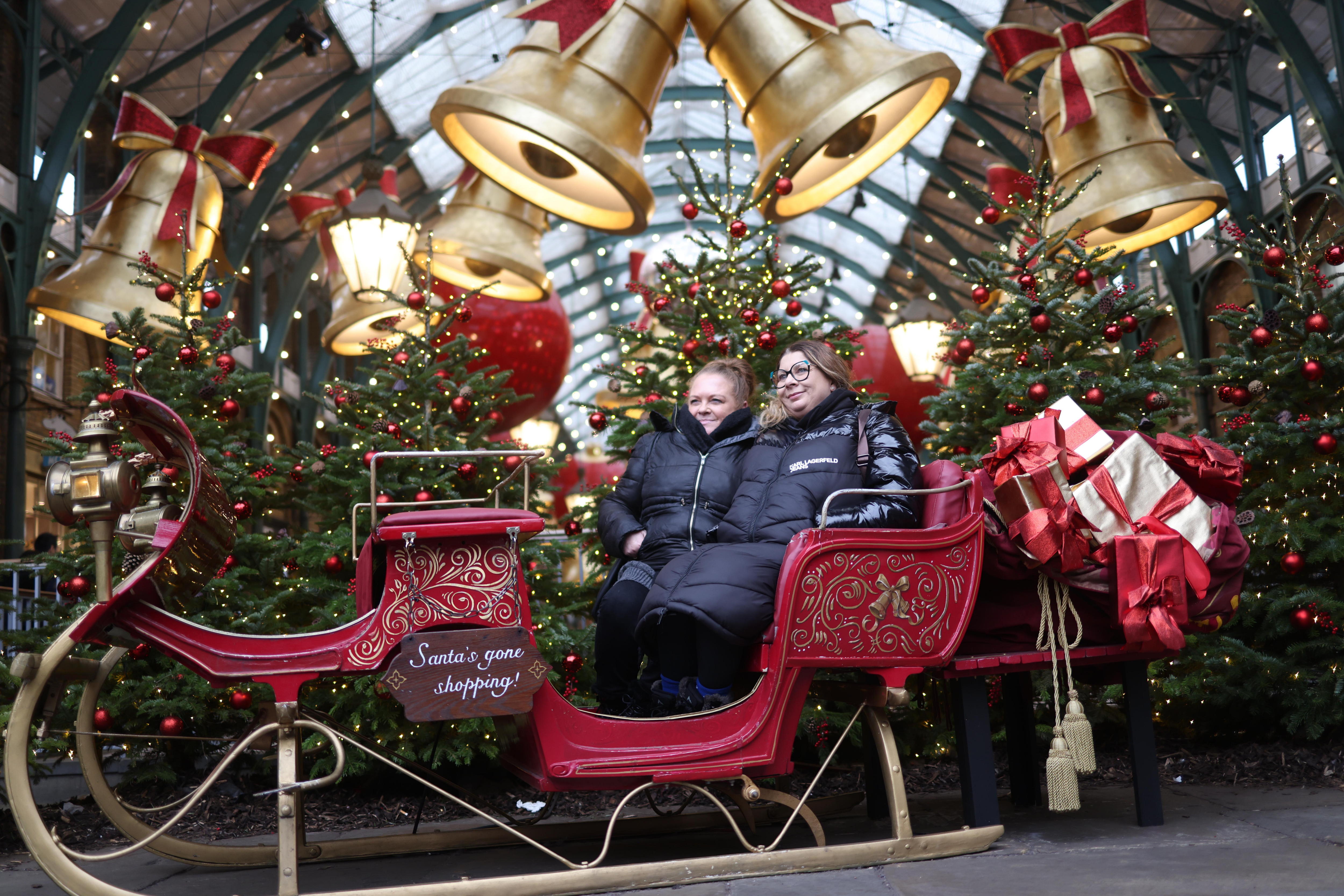 London (United Kingdom), 17/12/2024.- Shoppers pose for photographs while sitting in a sleigh, amidst decorations for the upcoming Christmas holiday, in London, Britain, 17 December 2024. (Reino Unido, Londres) EFE/EPA/NEIL HALL