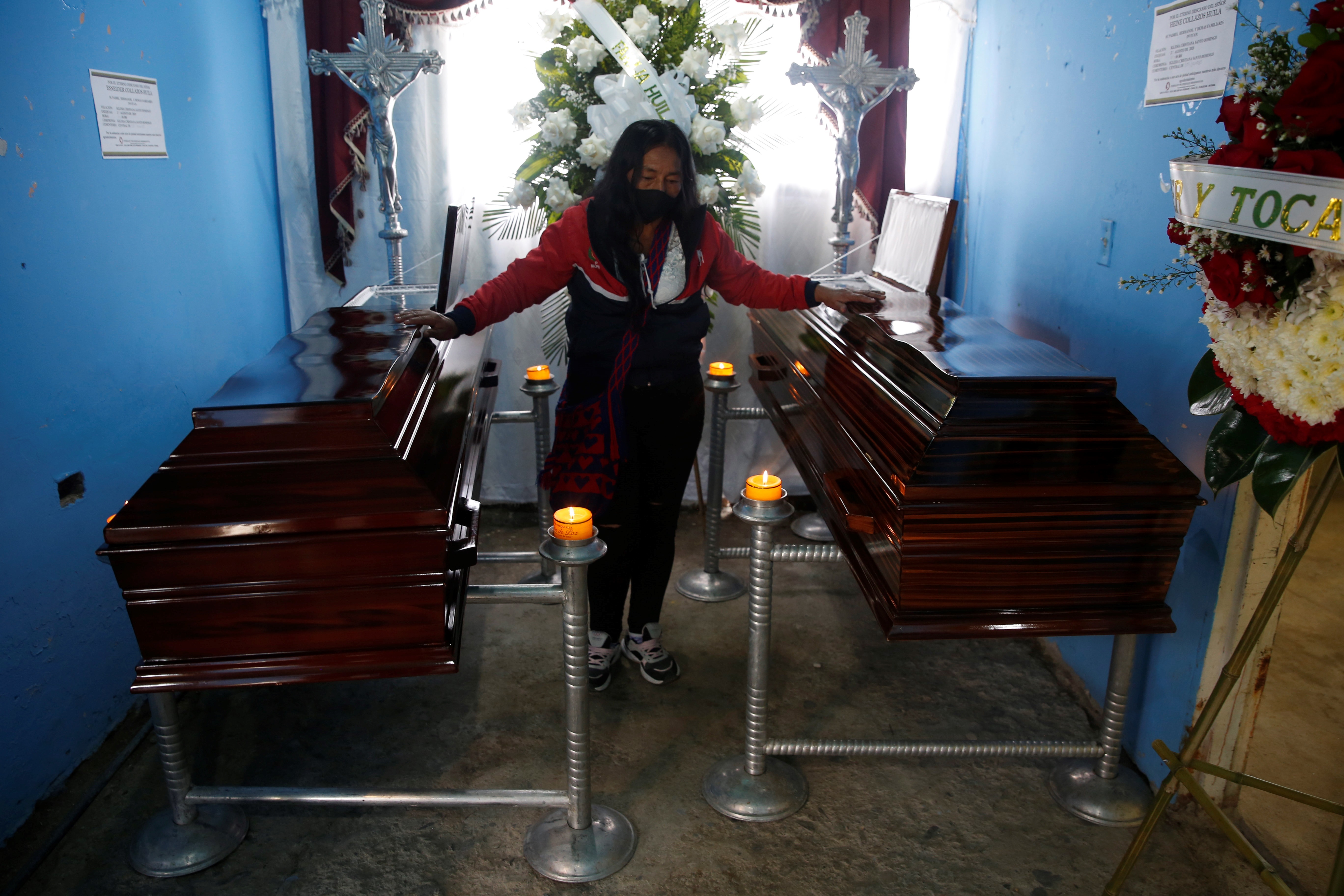 Lucila Huila toca los féretros de sus hijos Hiner y Esneider Collazos, asesinados en la masacre.
