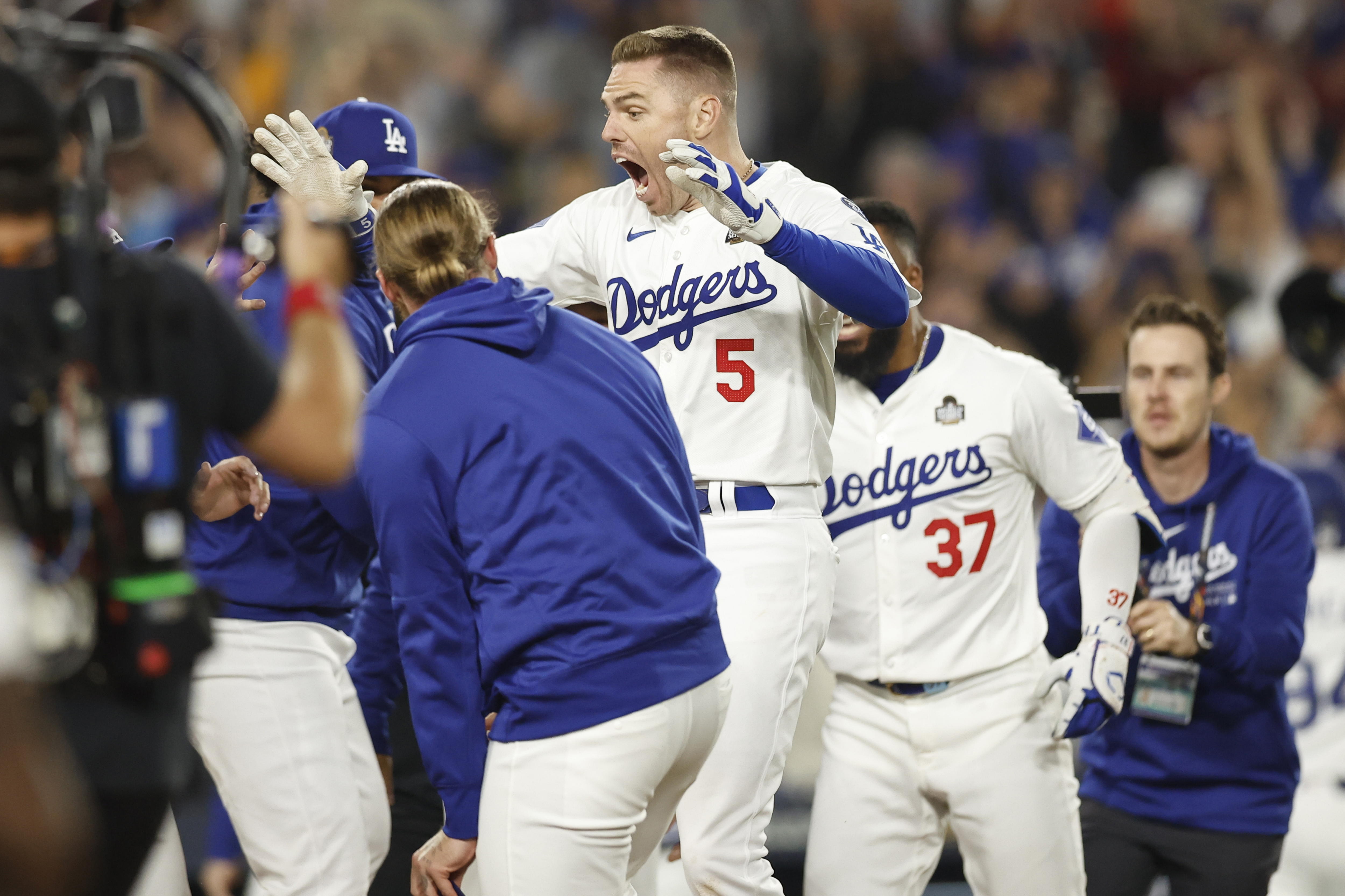 Los Angeles (United States), 25/10/2024.- Los Angeles Dodgers Freddie Freeman (C) is mobbed by his teammates while crossing home plate after hitting the game winning grand slam off a pitch by New York Yankees relief pitcher Nestor Cortes during the 10th inning of the Major League Baseball (MLB) World Series game one between the American League Champion New York Yankees and the National League Champion Los Angeles Dodgers in Los Angeles, California, USA, 25 October 2024. The World Series is the best-of-seven games. (Nueva York) EFE/EPA/CAROLINE BREHMAN