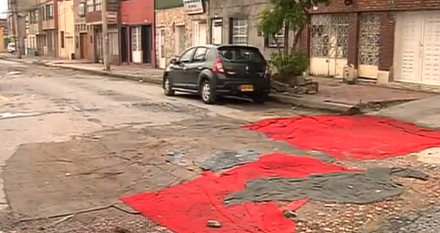 Con alfombras tapan huecos en barrio de Bogotá