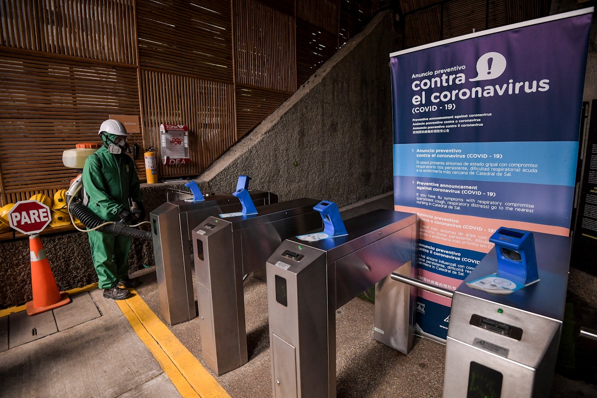 Un hombre rociando desinfectante con una máquina