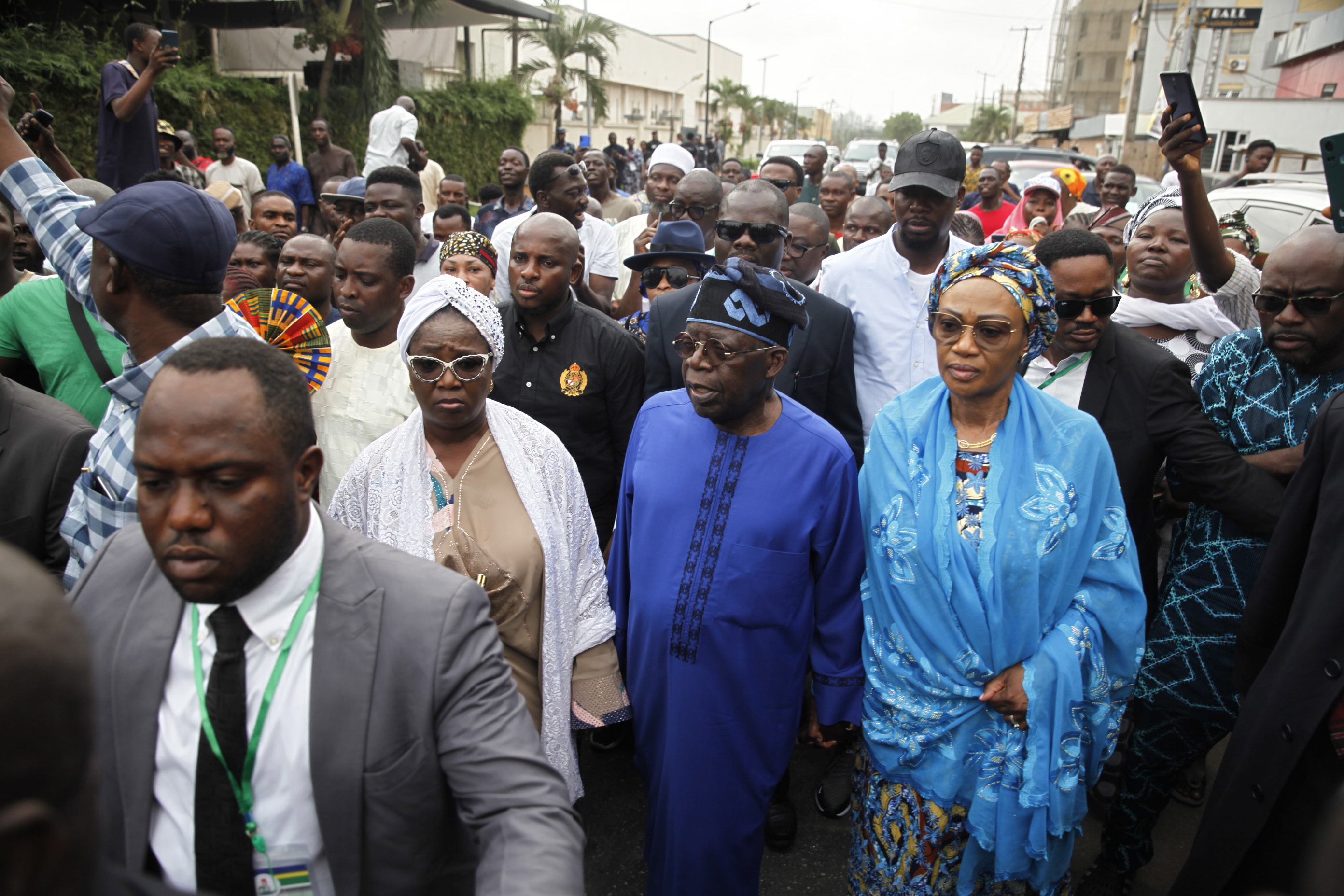 Lagos (Nigeria), 25/02/2023.- All Progressives Congress (APC)'s presidential candidate Bola Ahmed Tinubu (C), accompanied by his wife, Oluremi Tinubu (C-R), makes his way through the crowd after casting his vote at a polling station during the general elections, in the Ikeja district of Lagos, Nigeria, 25 February 2023. Nigerians head to the polls on 25 February to elect a new president, vice president and members of the Senate and House of Representatives. (Elecciones) EFE/EPA/AKINTUNDE AKINLEYE