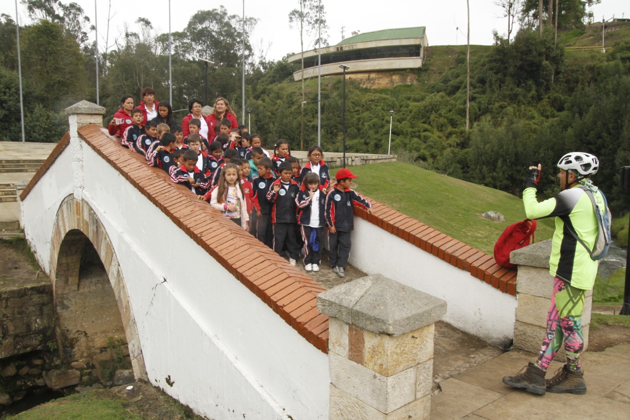 En el final del viaje en el Puente de Boyacá, niños del colegio Pantano de Vargas cantan para Pablo una canción que compusieron para el Bicentenario.Nelson CárdenasEl objetivo no era partir de Arauca y llegar a Puente de Boyacá sino distinguir lo más posible el contenido sensorial que había entre esos dos puntos, sumado al hecho de que usar la propia fuerza para desplazarse es entender, en carne propia, la dimensión de una subida, la dificultad de una superficie, el significado de 10 kilómetros. Ir en bici era escuchar las voces y el sentimiento de los seres que habitan en medio de esos dos extremos que recorrieron las tropas en 1819.