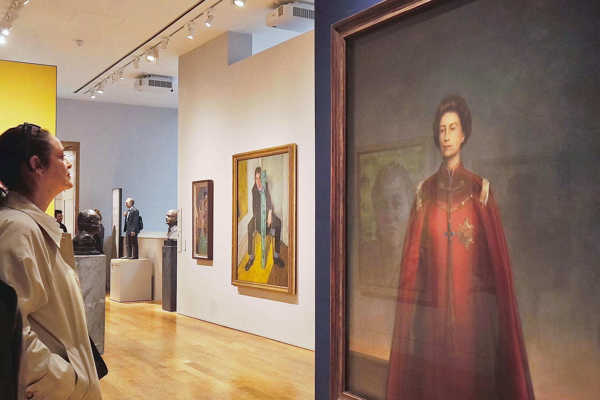 LONDRES, 21/04/2026.- Una mujer contempla un retrato de la reina Isabel II en la National Portrait Gallery de Londres. Este martes, se cumplen cien años del nacimiento de Isabel II, la reina que marcó la época contemporánea del Reino Unido, con siete décadas portando la corona, un tiempo en el que vio a su país perder todo un imperio, ingresar y luego salir de la Unión Europea, y que mantuvo un prestigio intacto pese a los escándalos que rodearon a buena parte de la familia real. EFE/ Guillermo Garrido