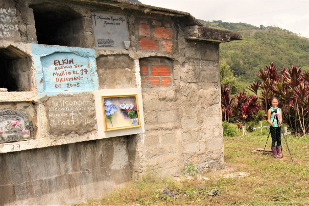 Una niña está tomando una foto en un cementerio de Dabeiba, Antioquia.