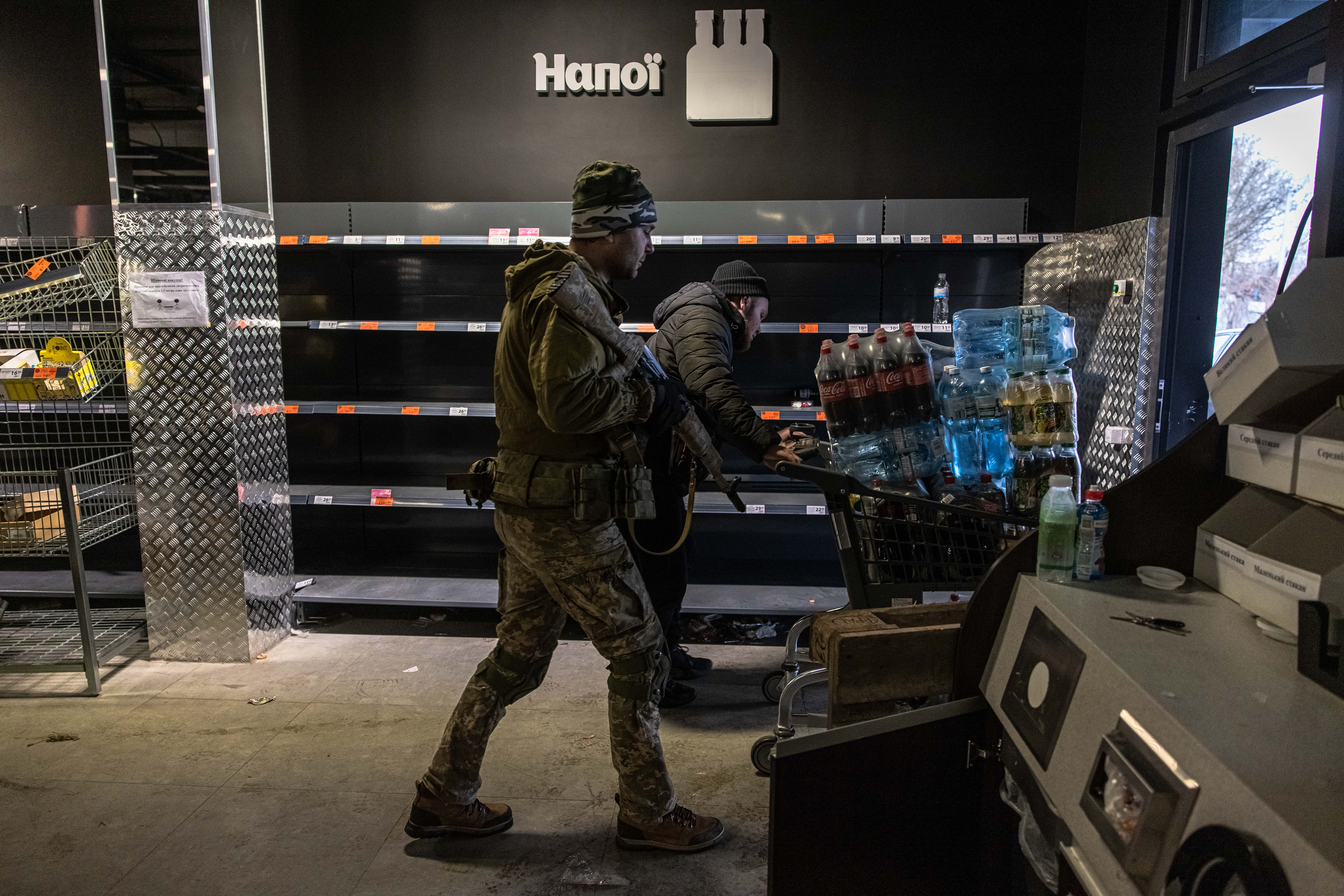 Kyiv (kiev) (Ukraine), 03/03/2022.- Ukrainian military members collect water and other goods from an abandoned supermarket to distribute on local residents, in Irpin city, Kyiv (Kiev) province, Ukraine, 03 March 2022. Russian troops entered Ukraine on 24 February prompting the country's president to declare martial law and triggering a series of severe economic sanctions imposed by Western countries on Russia. (Atentado, Rusia, Ucrania) EFE/EPA/ROMAN PILIPEY