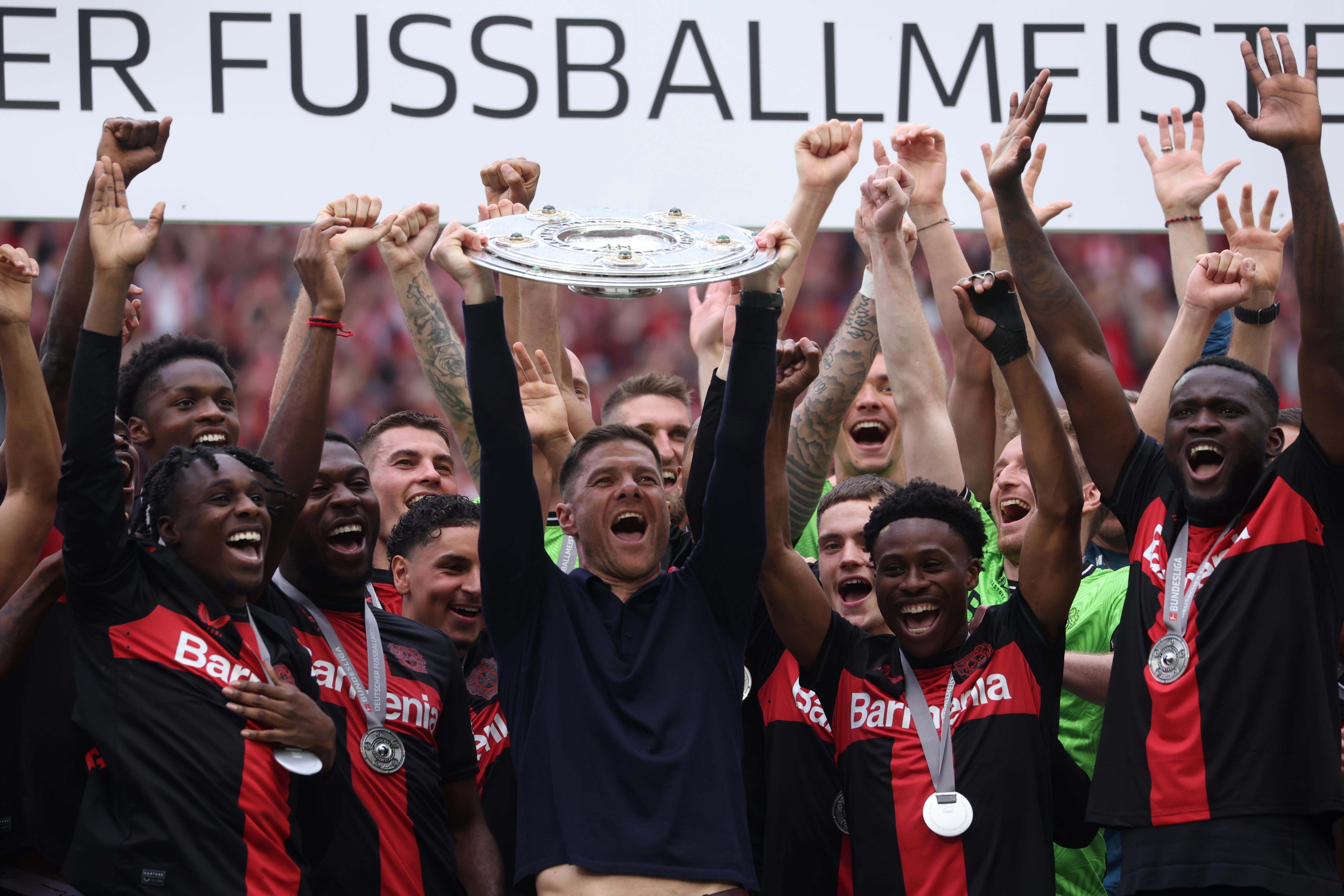 Leverkusen (Germany), 18/05/2024.- Leverkusen's head coach Xabi Alonso (C) lifts the Bundesliga trophy (Meisterschale) flanked by his players after the German Bundesliga soccer match of Bayer 04 Leverkusen against FC Augsburg, in Leverkusen, Germany, 18 May 2024. (Alemania) EFE/EPA/CHRISTOPHER NEUNDORF CONDITIONS - ATTENTION: The DFL regulations prohibit any use of photographs as image sequences and/or quasi-video.