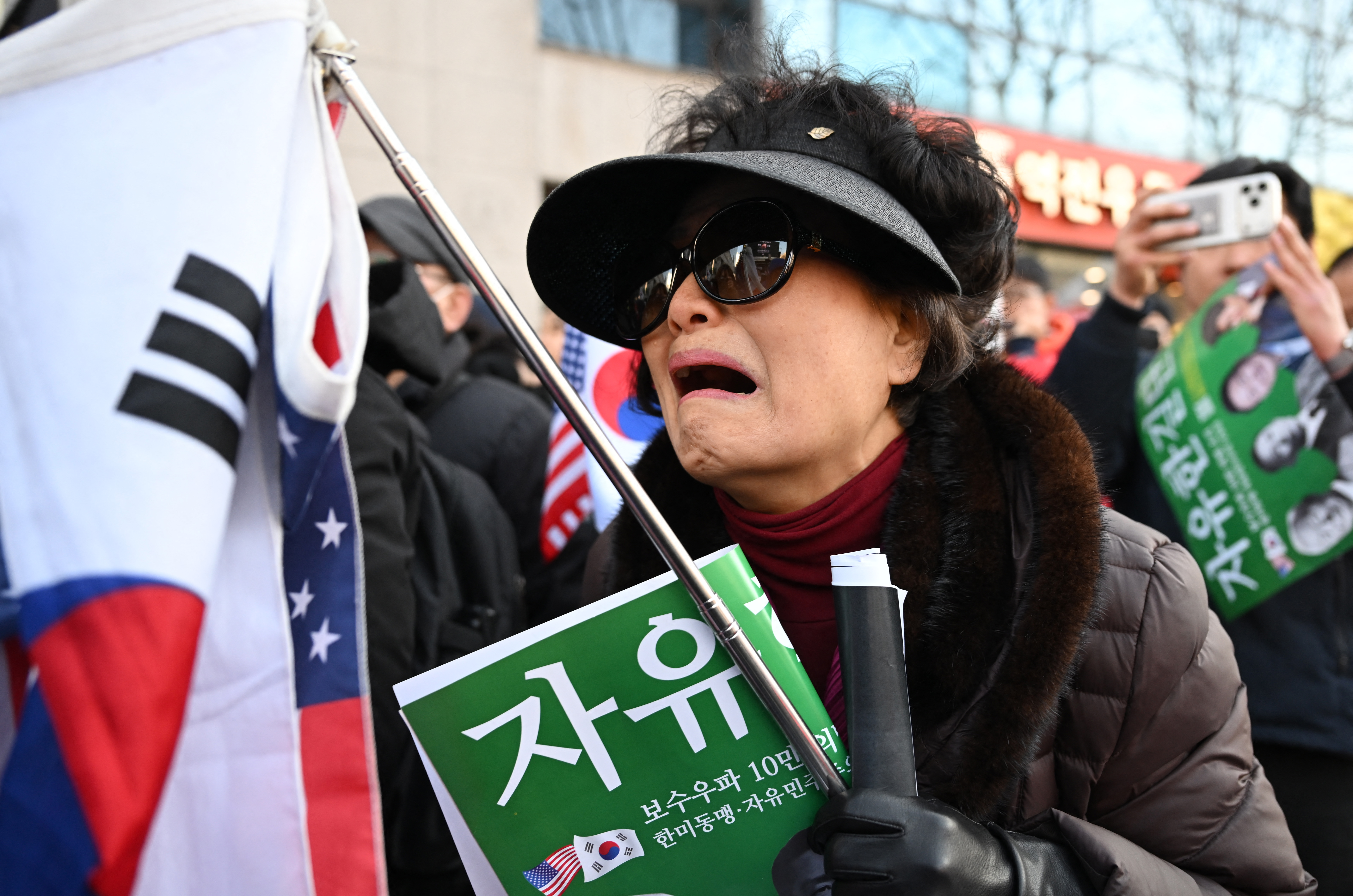 Partidarios del expresidente surcoreano destituido, Yoon Suk Yeol, reaccionan mientras ven una transmisión en vivo del juicio contra Yoon por sus cargos de insurrección cerca del Tribunal del Distrito Central de Seúl, el 19 de febrero de 2026.