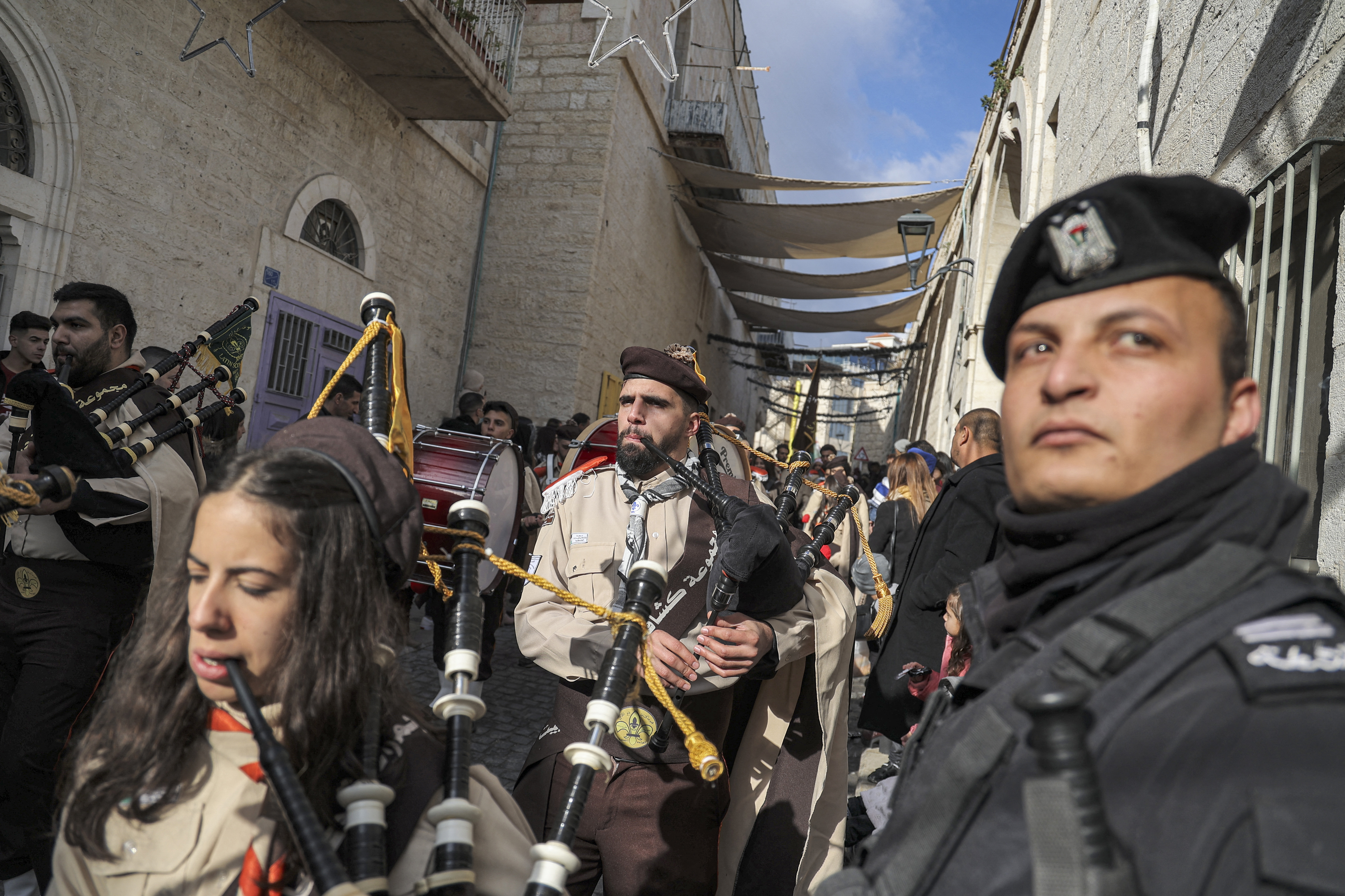 Los miembros de la banda del movimiento scouting actúan en un desfile frente a la Iglesia de la Natividad durante las celebraciones navideñas en la ciudad bíblica de Belén en la ocupada Cisjordania en la víspera de Navidad