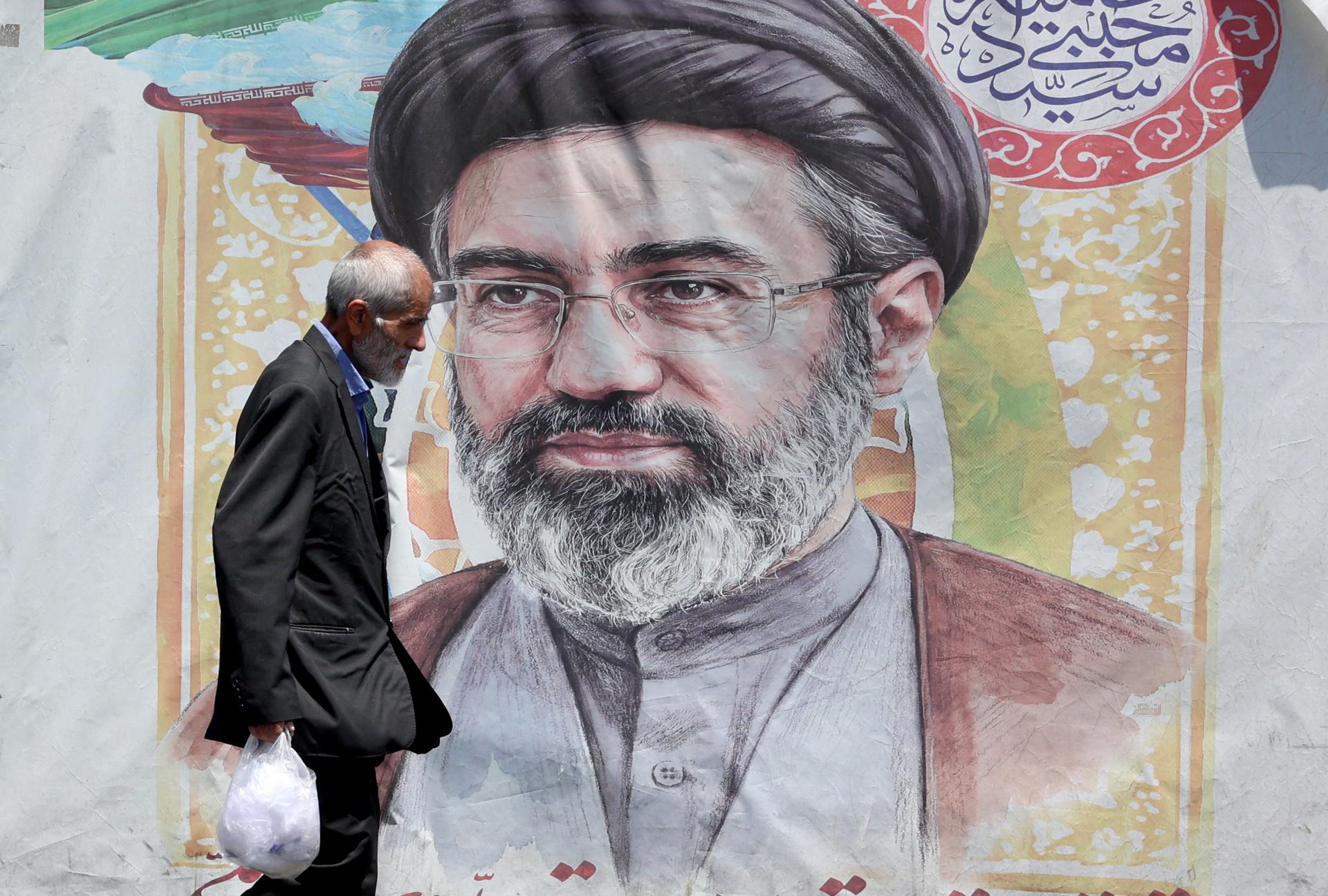 FOTODELDÍA TEHERÁN (IRÁN (República Islámica de)), 18/06/2026.- Un hombre iraní pasa junto a un cartel del líder supremo iraní, el ayatolá Mojtaba Khamenei, en una calle de Teherán, Irán. Irán y Estados Unidos firmaron un acuerdo de paz para poner fin a la guerra entre ambos países. (Teherán) EFE/EPA/ABEDIN TAHERKENAREH RESTRICCIONES: Prohibido el acceso a medios de comunicación israelíes/canales de televisión en persa fuera de Irán/Estrictamente prohibido el acceso a BBC Persian/VOA Persian/Manoto TV/Televisión Internacional de Irán. (Según lo dispuesto por la Dirección General de Medios de Comunicación Extranjeros de Irán) --
