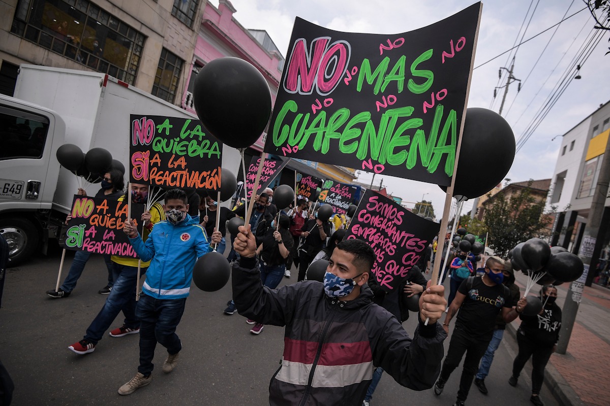 Varias personas sostienen carteles que dicen: no más cuarentena.