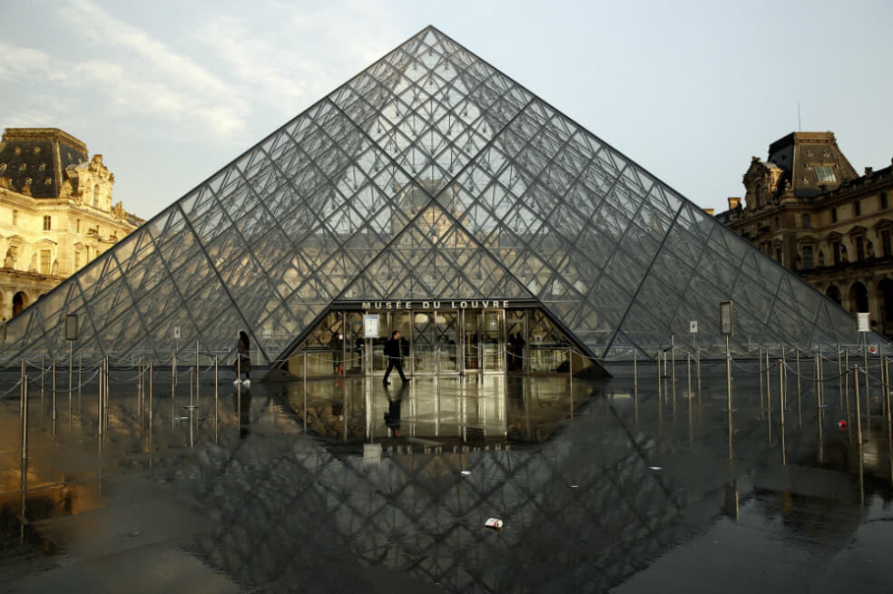 Los visitantes pasan por la pirámide del Museo del Louvre en París, Francia, el 1 de marzo de 2020. / EFE