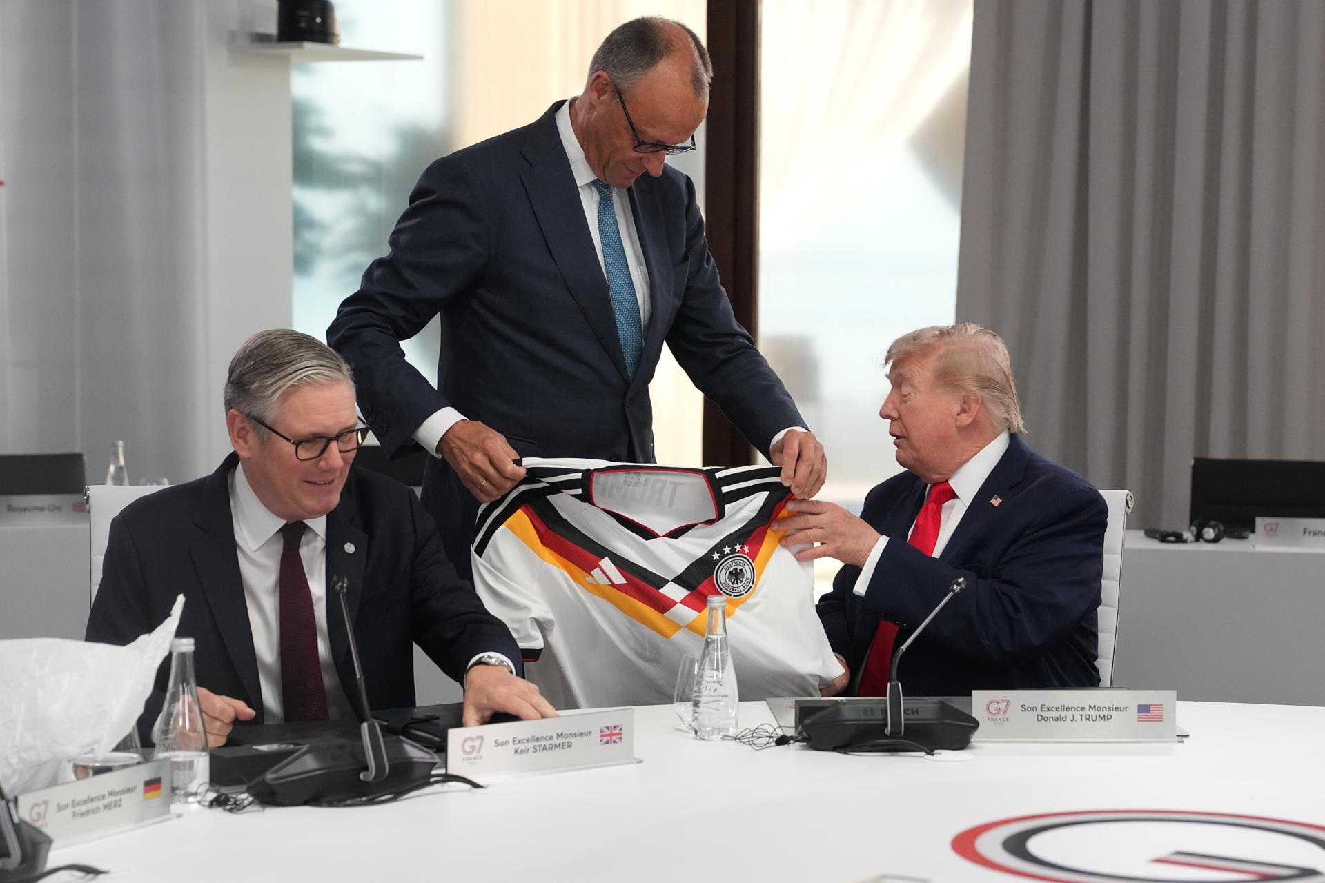 Evian-les-Bains (FRA), 16/06/2026.- German Chancellor Friedrich Merz (C) presents US President Donald Trump (R) with a jersey with the number 47 on it as British Prime Minister Keir Starmer (L) looks on during a working session at the G7 summit in Evian-les-Bains, France, 16 June 2026. The 52nd G7 Summit takes place in Evian-les-Bains from 15 to 17 June 2026. (Francia) EFE/EPA/THIBAULT CAMUS / POOL MAXPPP OUT
