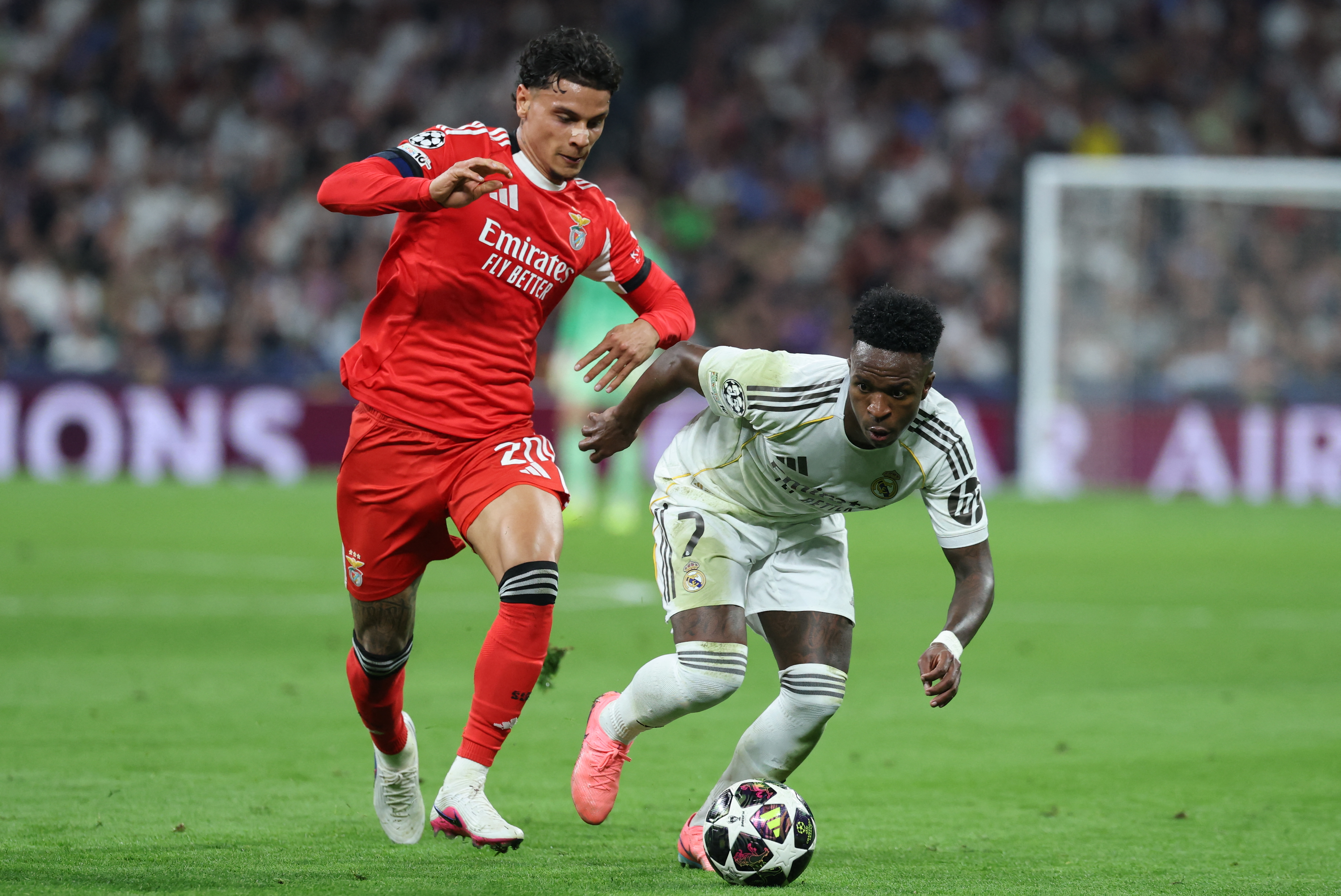 SL Benfica's Colombian midfielder #20 Richard Rios (L) and Real Madrid's Brazilian forward #07 Vinicius Junior fight for the ball during the UEFA Champions League knockout round play-off second leg football match between Real Madrid CF and SL Benfica at Santiago Bernabeu Stadium in Madrid on February 25, 2026. (Photo by Thomas COEX / AFP)