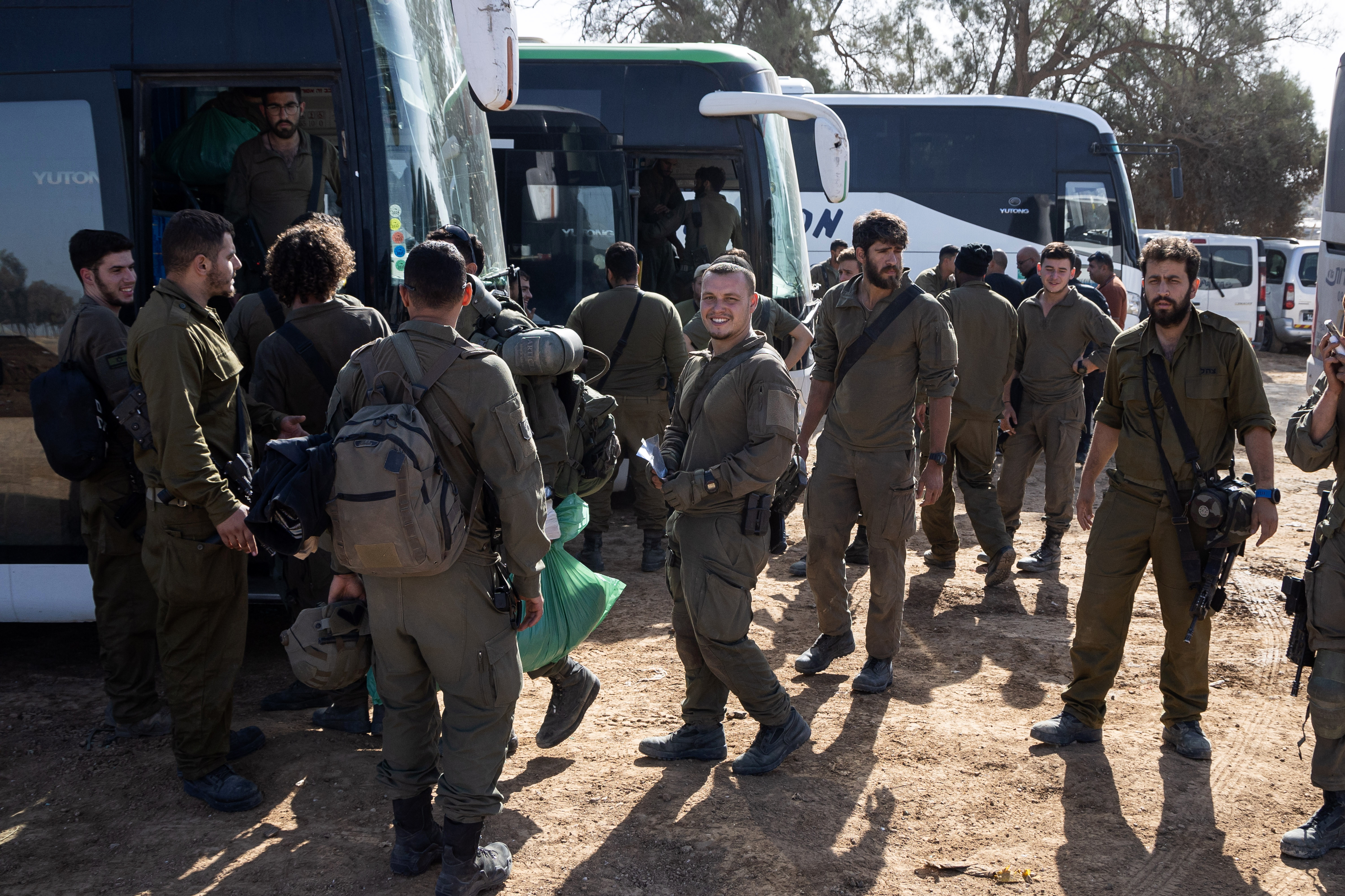 Soldados israelíes se preparan para salir junto a autobuses en la frontera con la Franja de Gaza, en el sur de Israel.