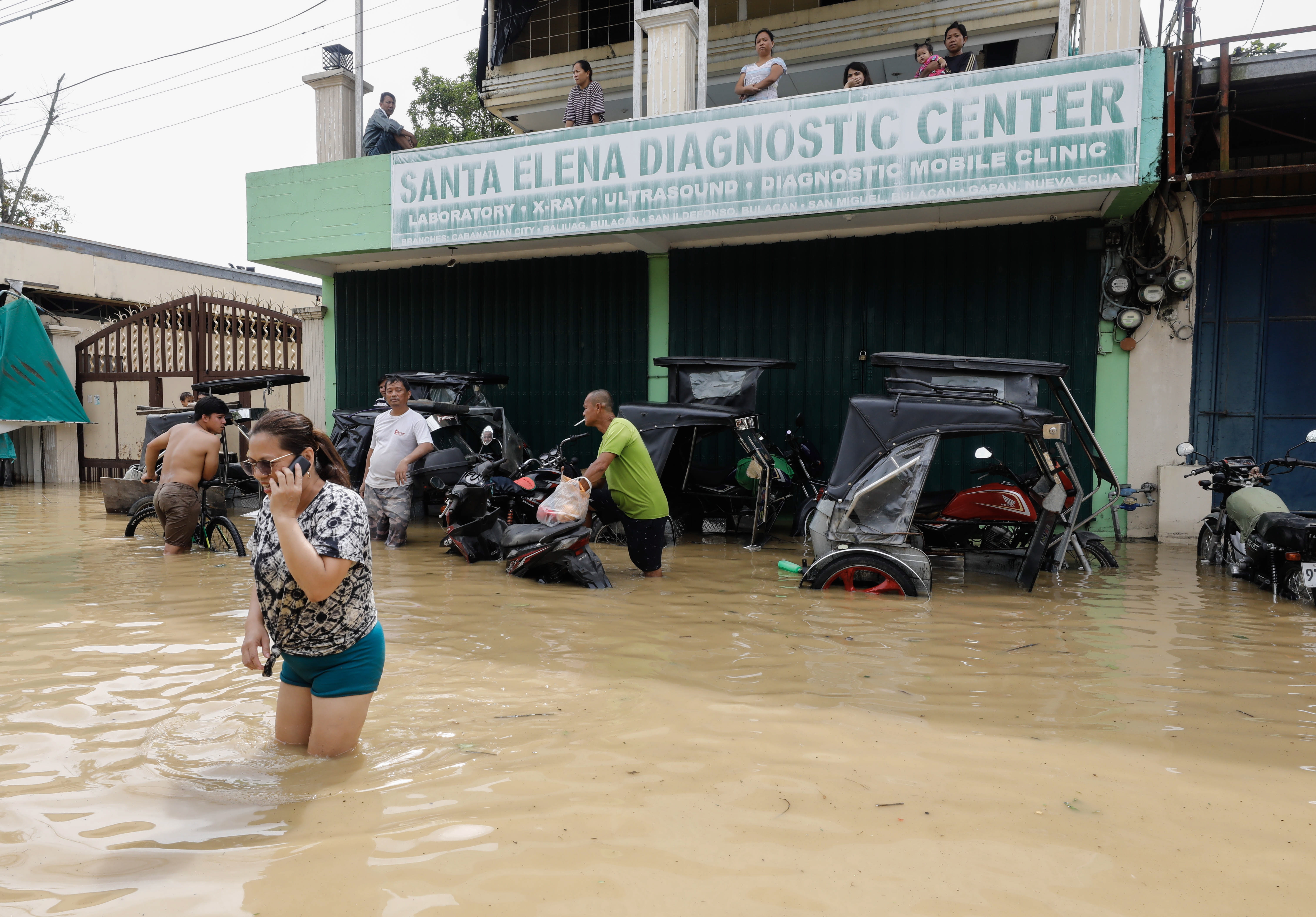 Bulacan (Philippines), 26/09/2022.- Residents stay on an upper floor while others wade through flood water caused by typhoon Noru in San Miguel town of Bulacan province, north of Manila, Philippines 26 September 2022. Typhoon Noru crossed the northern Philippine region of Luzon on 25 September and prompted thousands to evacuate due to heavy rain and strong winds. Typhoon Noru is expected to leave the Philippine area of responsibility by evening of 26 September. (Filipinas, Estados Unidos) EFE/EPA/ROLEX DELA PENA