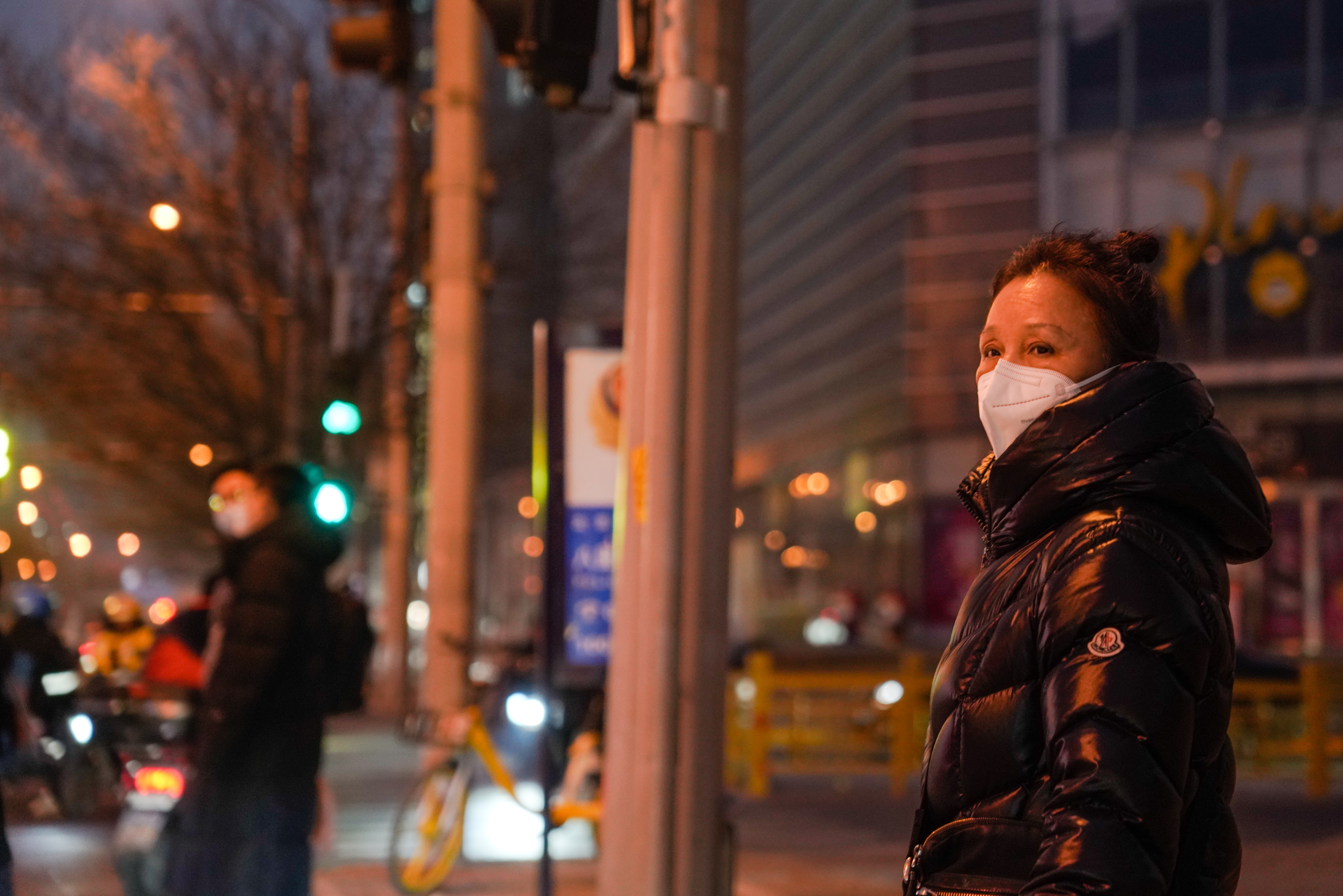 Beijing (China), 11/01/2023.- A woman wearing a face mask stands on street in Beijing, China, 11 January 2023. Chinese state media defended on 11 January China's countermeasures against South Korea and Japan over their inbound COVID-19 travel curbs as 'reasonable', while Chinese tourists criticized Seoul's 'insulting' treatment on social media. (Japón, Corea del Sur, Seúl) EFE/EPA/WU HAO