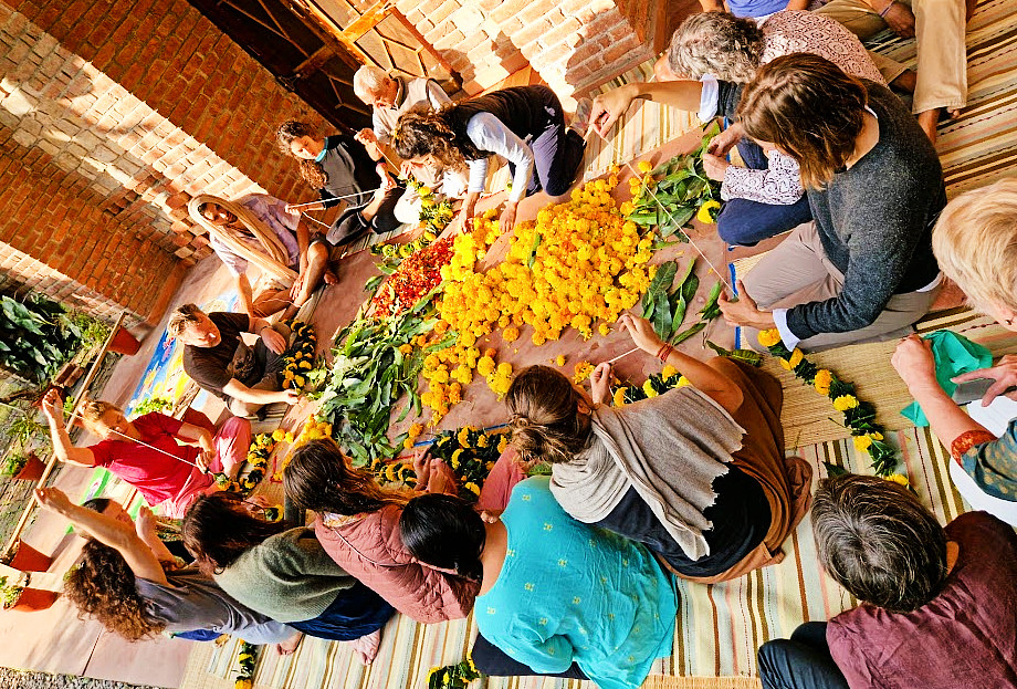 El grupo en Yoganga armando guirnaldas hechas con hojas de mango (que son auspiciosas) y flores de caléndula con diferentes tonos de amarillo y rojo para colocarle a Hanuman, a Ganesha y a Patanjali.