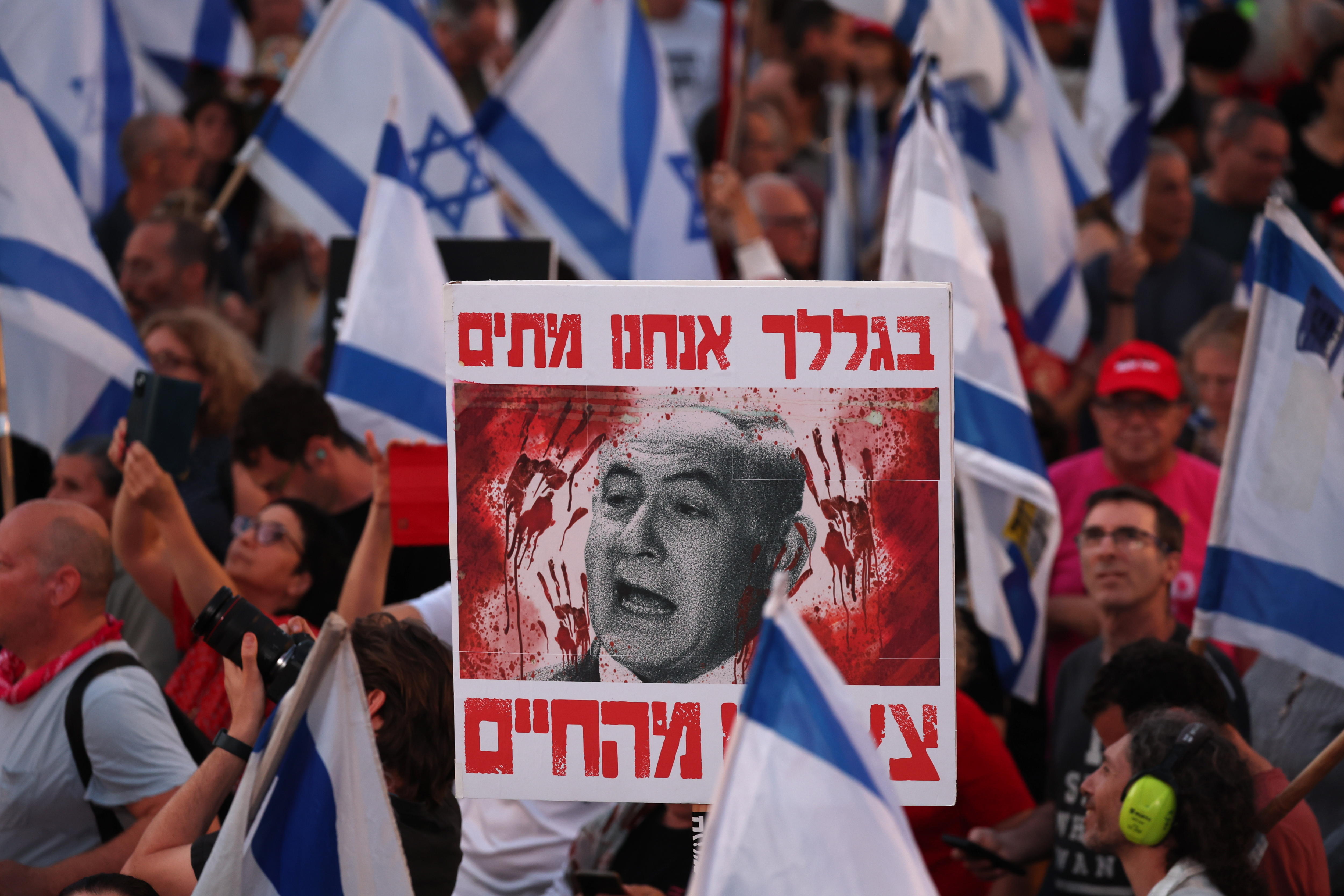 Tel Aviv (Israel), 11/05/2024.- A person holds a placard depicting Israeli Prime Minister Netanyahu and reading "because of you we are dead" during a protest calling for the release of hostages held by Hamas in Gaza, and for the government to step down, near the Kirya in Tel Aviv, Israel, 11 May 2024. According to data released by the Israel Defense Forces, 133 Israelis were still being held in Gaza after being kidnaped in the 07 October 2023 Hamas attack in Israel. (Protestas) EFE/EPA/ATEF SAFADI