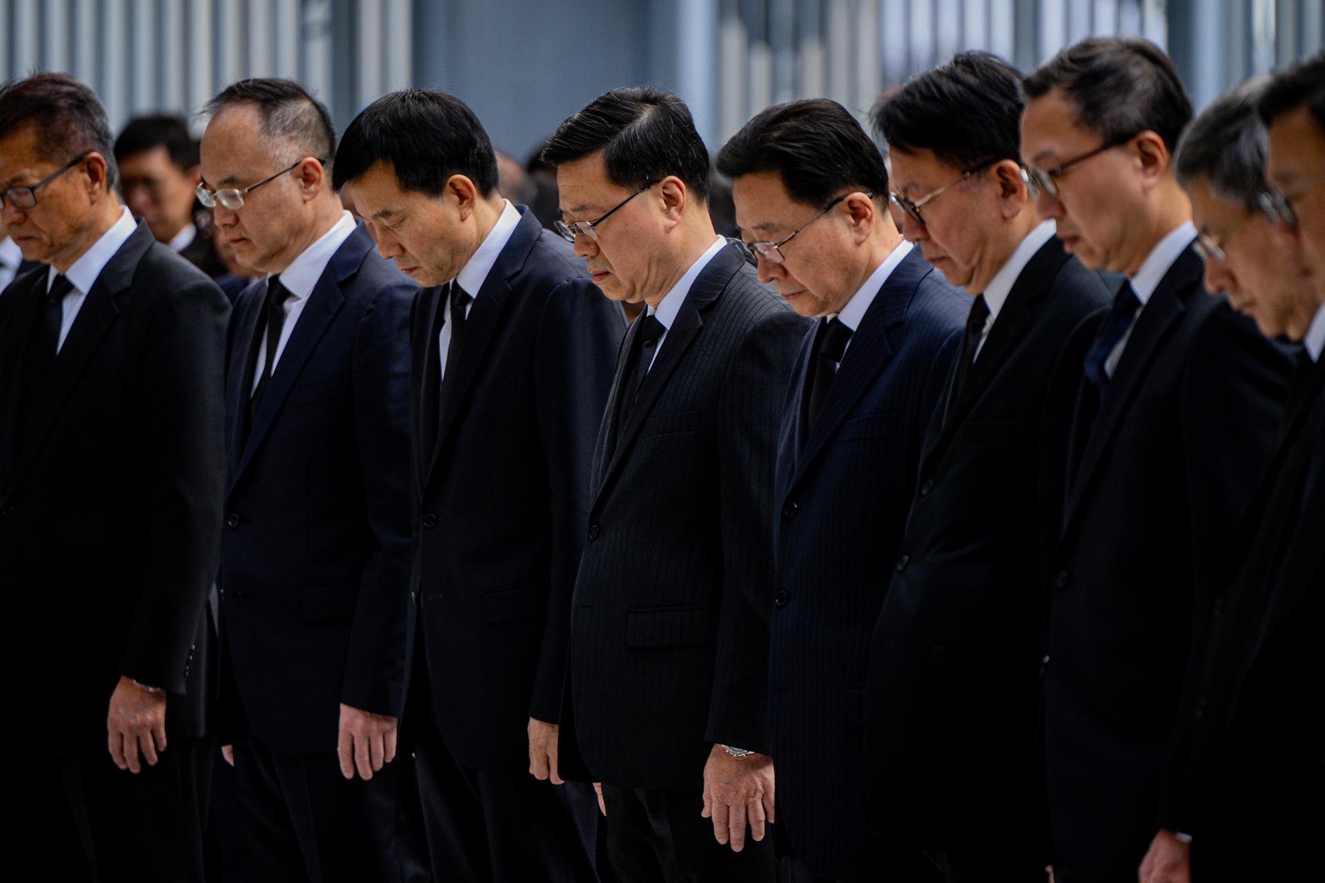 HONG KONG (China), 29/11/2025.- Hong Kong Chief Executive John Lee (4-L), principal officials, non-official members of the Executive Council and civil servants observe a minute of silence as the Hong Kong and Chinese national flags fly at half-mast in mourning for the victims of the Tai Po fire, in Hong Kong, China, 29 November 2025. EFE/EPA/LEUNG MAN HEI