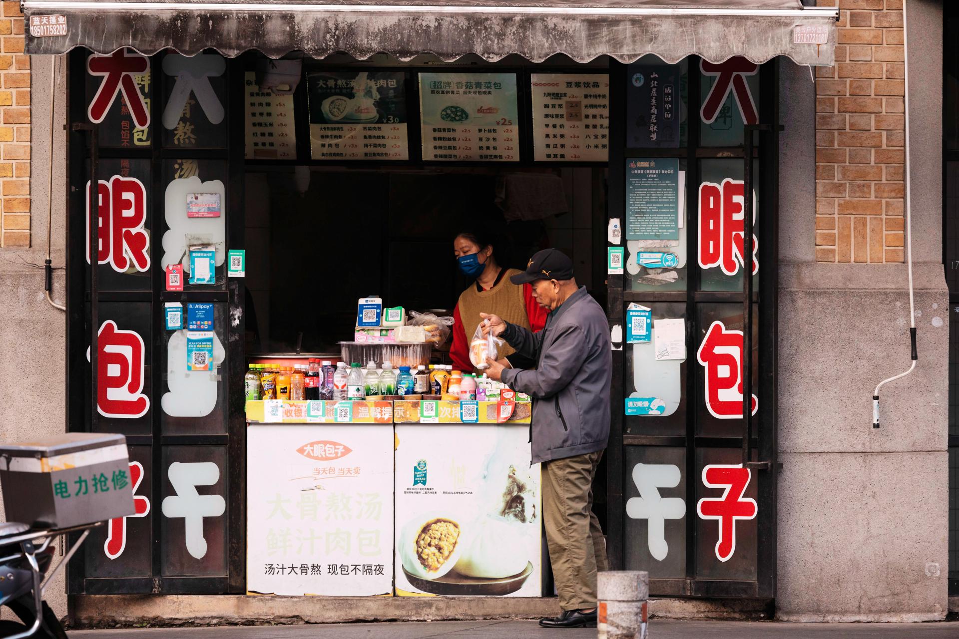 Shanghai (China), 30/11/2025.- A man buys food from a street-side shop in Shanghai, China, 30 November 2025. The National Bureau of Statistics of China reported that the Manufacturing Purchasing Managers' Index (PMI) for November 2025 rose to 49.2 from October’s six-month low of 49.0, meeting market expectations. Despite this increase, factory activity contracted for the eighth consecutive month, as manufacturers faced weak demand, heightened domestic price competition, and cautious export sentiment amid global uncertainty. EFE/EPA/ALEX PLAVEVSKI