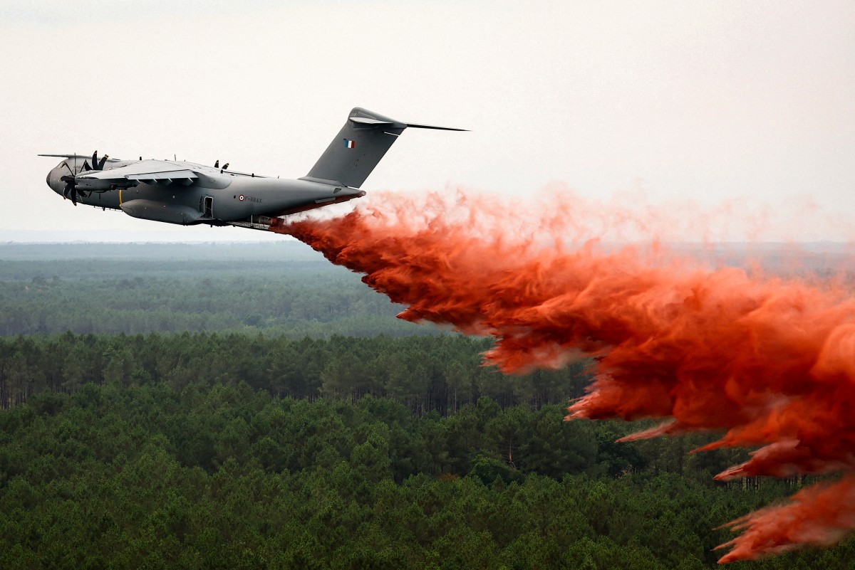 (FILES) This photograph taken from the French Civil Security rescue coordination helicopter shows a French Air Force military transport A400M aircraft making its first-ever drop of fire retardant over the wildfire near Lacanau, southwestern France, on July 25, 2026.
