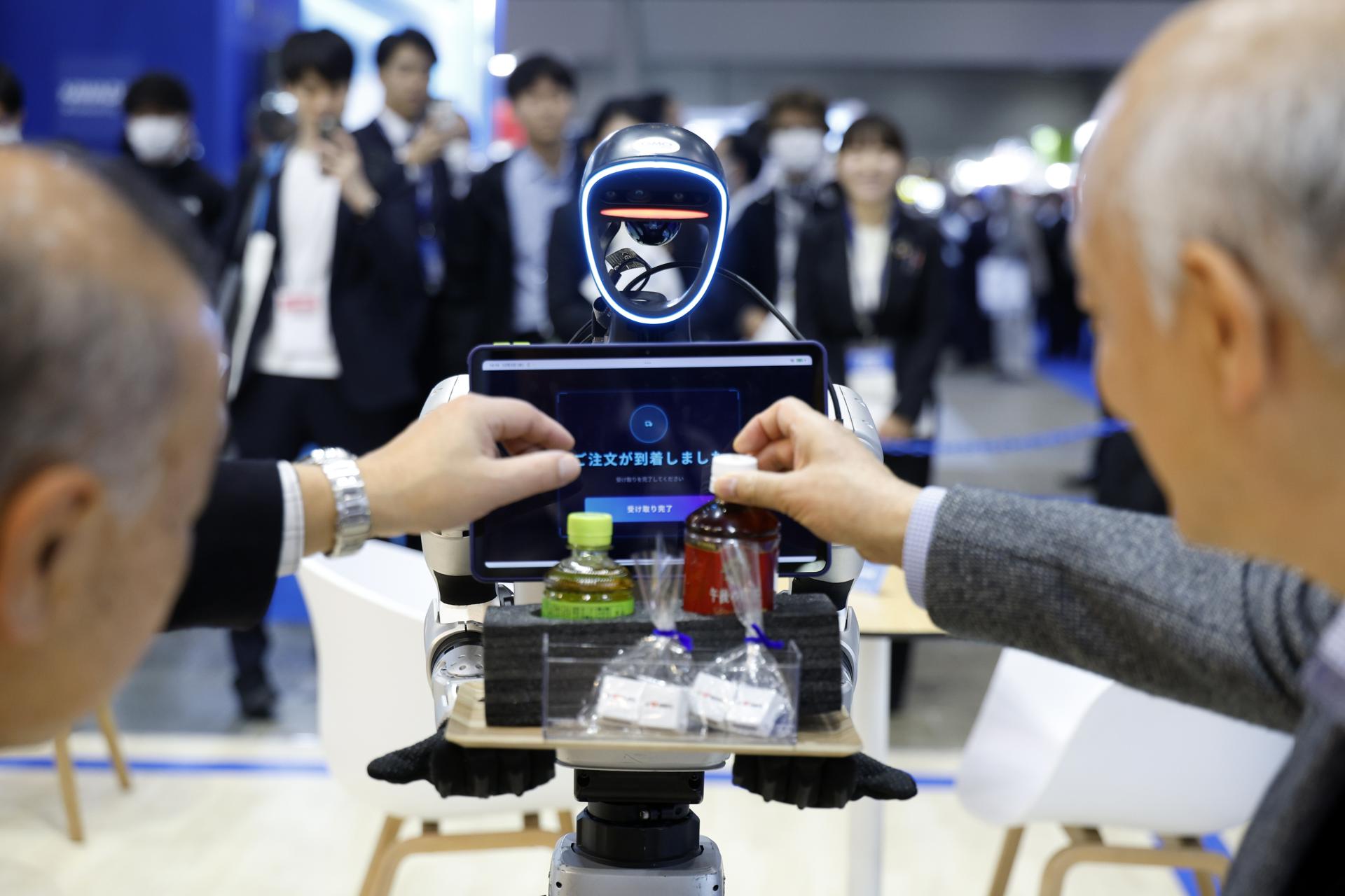 TOKYO (Japan), 03/12/2025.- Visitors are served drinks by a robot at the GMO AI and Robotics Corporation booth during the International Robot Exhibition 2025 (iREX2025) in Tokyo, Japan, 03 December 2025. Held once every two years, the iREX is one of the world’s largest robot trade shows. For the 2025 edition, 673 companies and organizations will be presenting their latest robot technologies until 06 December. (Japón, Tokio) EFE/EPA/FRANCK ROBICHON