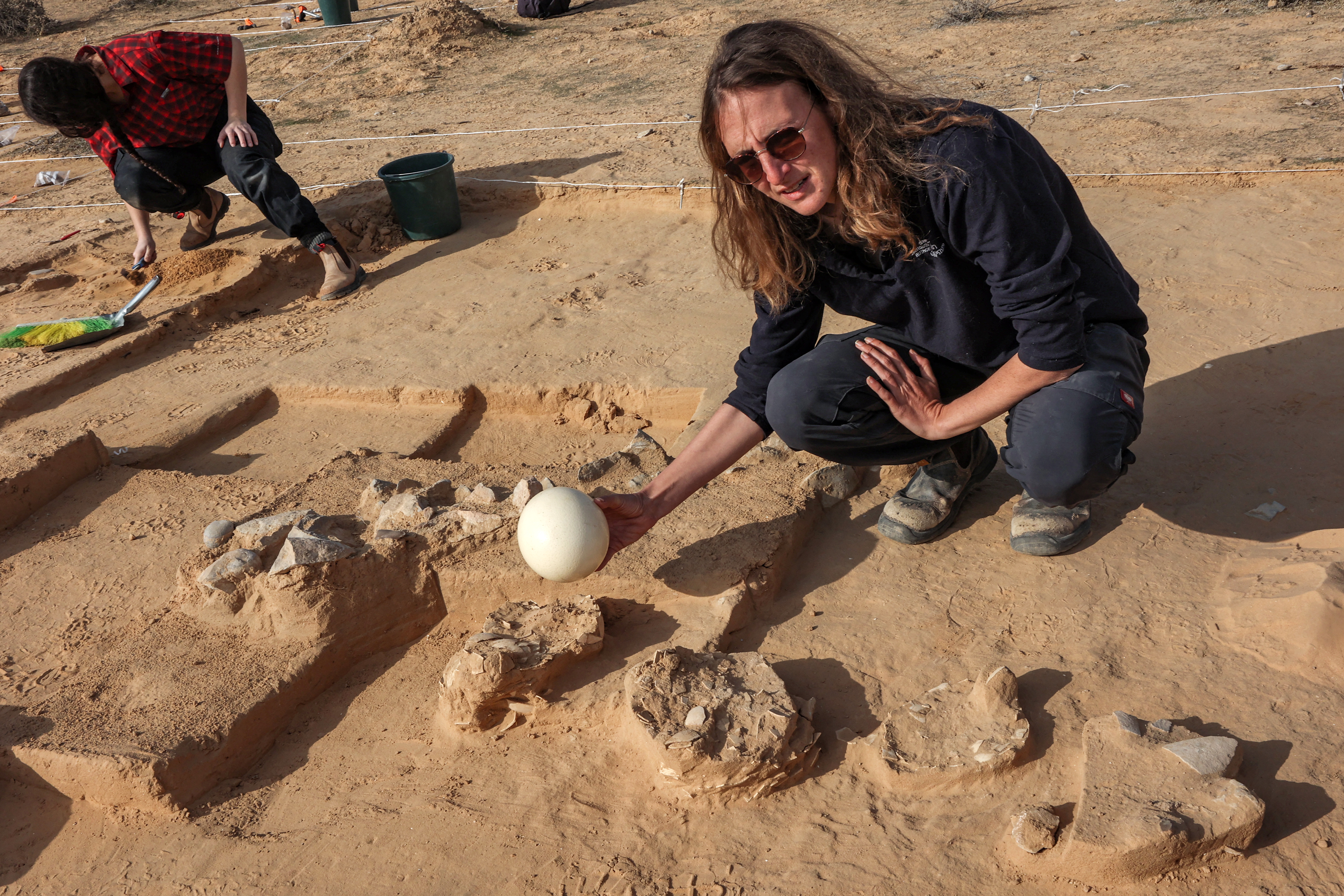 This picture taken on January 12, 2023 shows a view of discovered ostrich egg fragments dating over 4000 years discovered by the Israel Antiquities Authority (IAA) at a site in the dunes near Nitzana along the Israel-Egypt border in the western Negev desert. - Experts say the finds provide insight into the life of the ancient peoples inhabiting the region. The eight crushed eggs were located at a camp site used by nomads "since prehistoric times," said Lauren Davis, the Israel Antiquities Authority excavation director. Their proximity to the fire, alongside stones, flint, tools and pottery sherds, implies that the eggs were to be cooked, said Davis. (Photo by GIL COHEN-MAGEN / AFP)