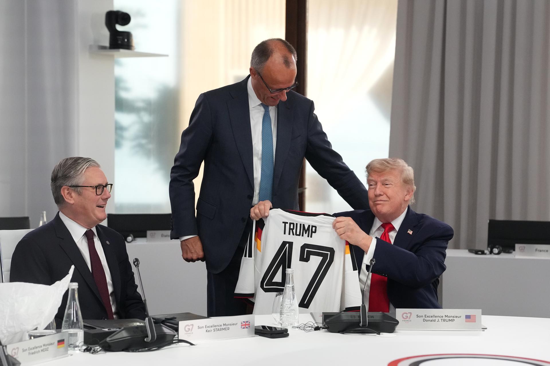 Evian-les-Bains (FRA), 16/06/2026.- US President Donald Trump (R) holds up a jersey with the number 47 on it as British Prime Minister Keir Starmer (L), and German Chancellor Friedrich Merz (C) look on during a working session at the G7 summit in Evian-les-Bains, France, 16 June 2026. The 52nd G7 Summit takes place in Evian-les-Bains from 15 to 17 June 2026. (Francia) EFE/EPA/THIBAULT CAMUS / POOL MAXPPP OUT