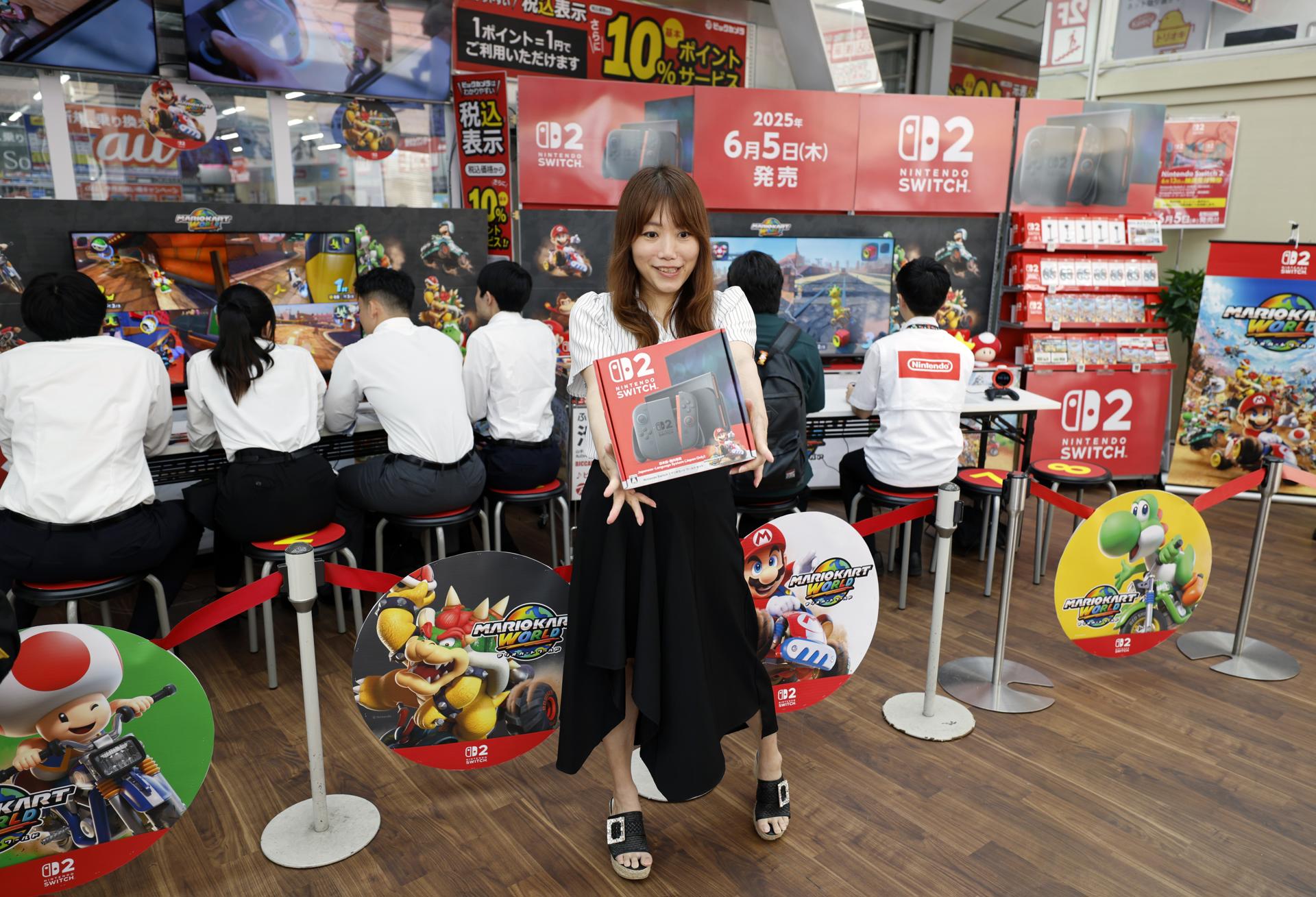 TOKYO (Japan), 05/06/2025.- A young woman holds the box of the new Nintendo Switch 2 gaming console at a consumer electronics retailer in Tokyo, Japan, 05 June 2025. On 05 June 2025, Nintendo released its new video game console, the 'Nintendo Switch 2.' This is the first successor model in about eight years since the original Switch was launched in 2017. The first lottery held in April for pre-orders attracted around 2.2 million people in Japan alone. (Japón, Tokio) EFE/EPA/FRANCK ROBICHON