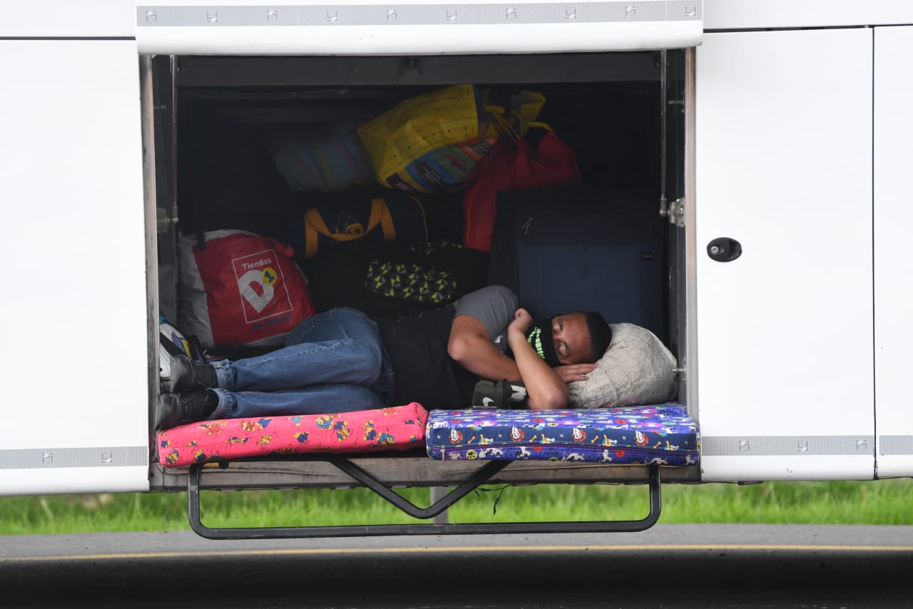 Las imágenes, incluso muestran a personas durmiendo en las bodegas de equipaje de los buses, así como ambién a niños cubiertos con tapabocas y de la mano de sus padres en medio del trayecto.