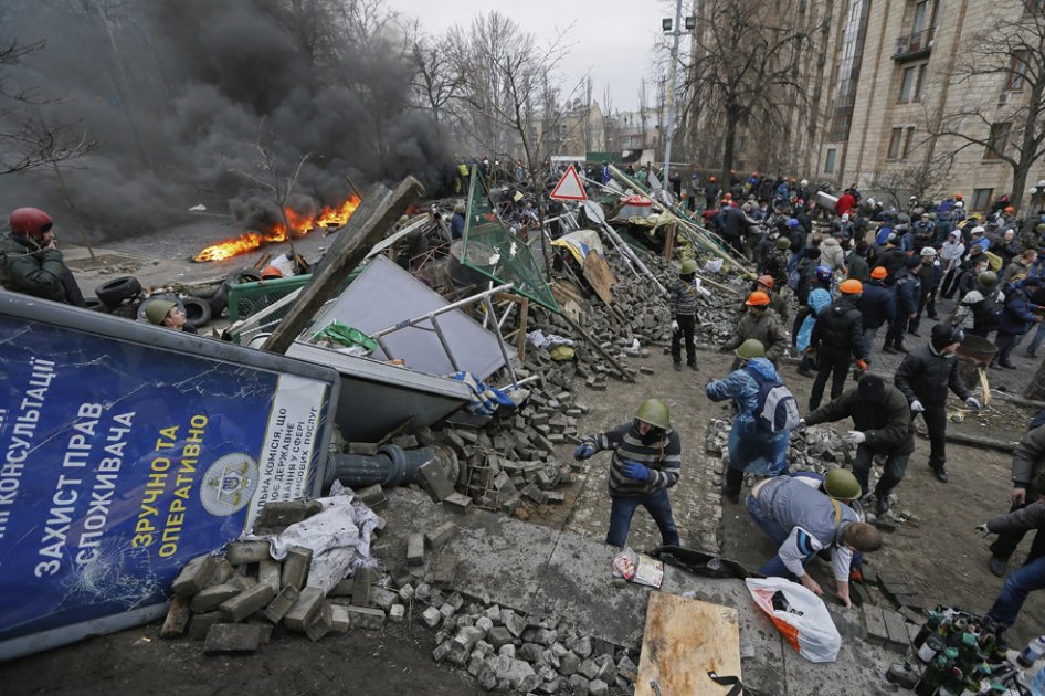 Numerosos manifestantes construyen una barricada después de los disturbios entre opositores y policía, en Kiev (Ucrania)
