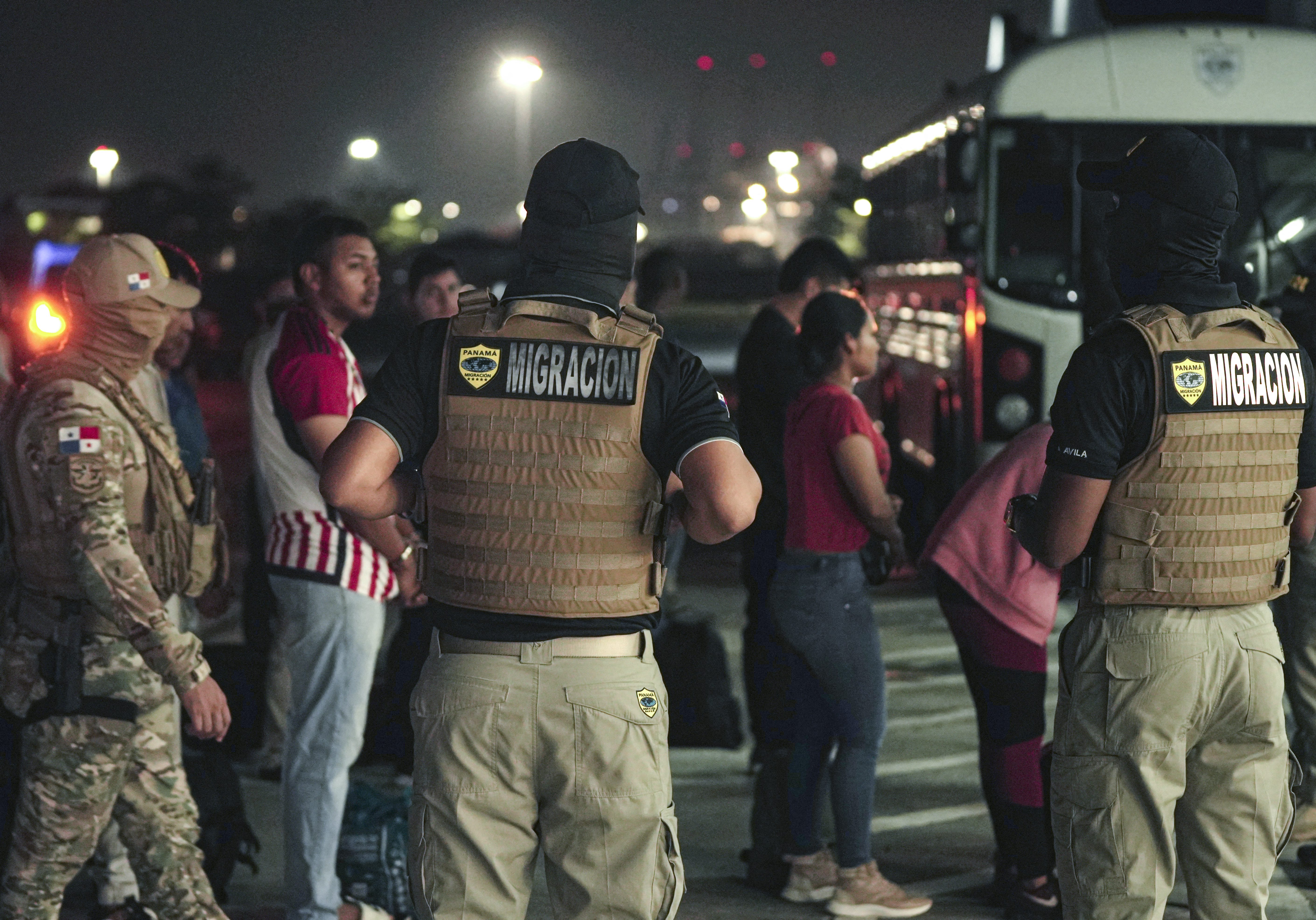 Oficiales de migración protegen a ciudadanos colombianos mientras esperan ser deportados en el aeropuerto de Albrook Gelabert en la ciudad de Panamá el 17 de mayo.