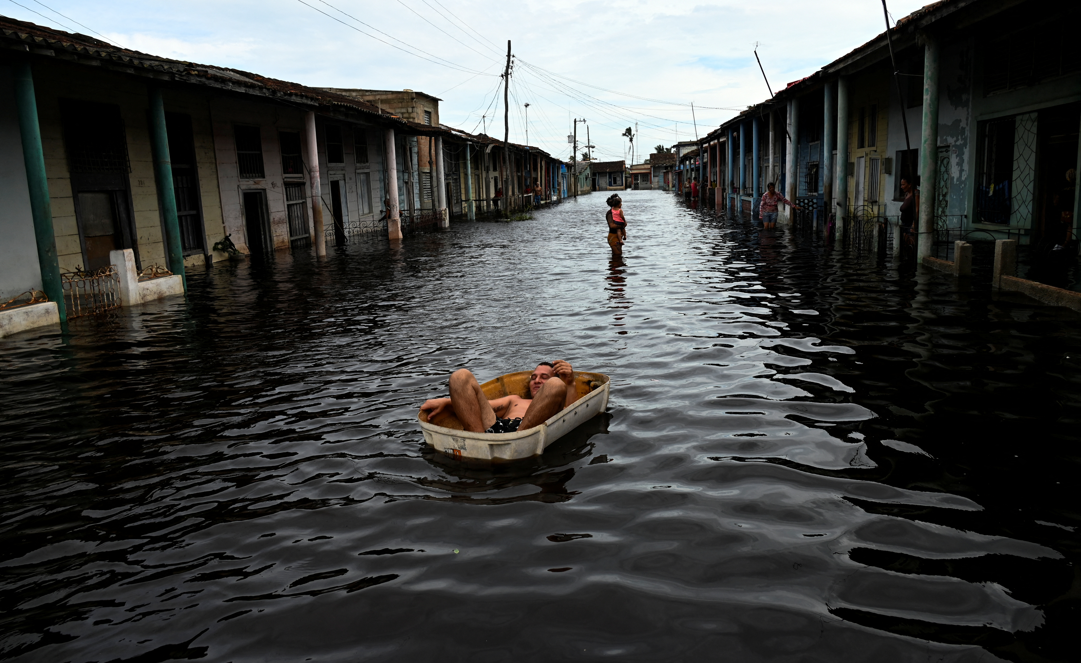TOPSHOT - A man rides a handmade raft through a flooded street in Batabano, Mayabeque province, Cuba, on September 26, 2024, following the passage of Hurricane Helene.